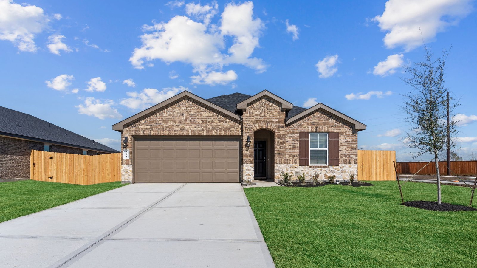 Newly built single story home with modern architecture, a double garage, and landscaped front yard.