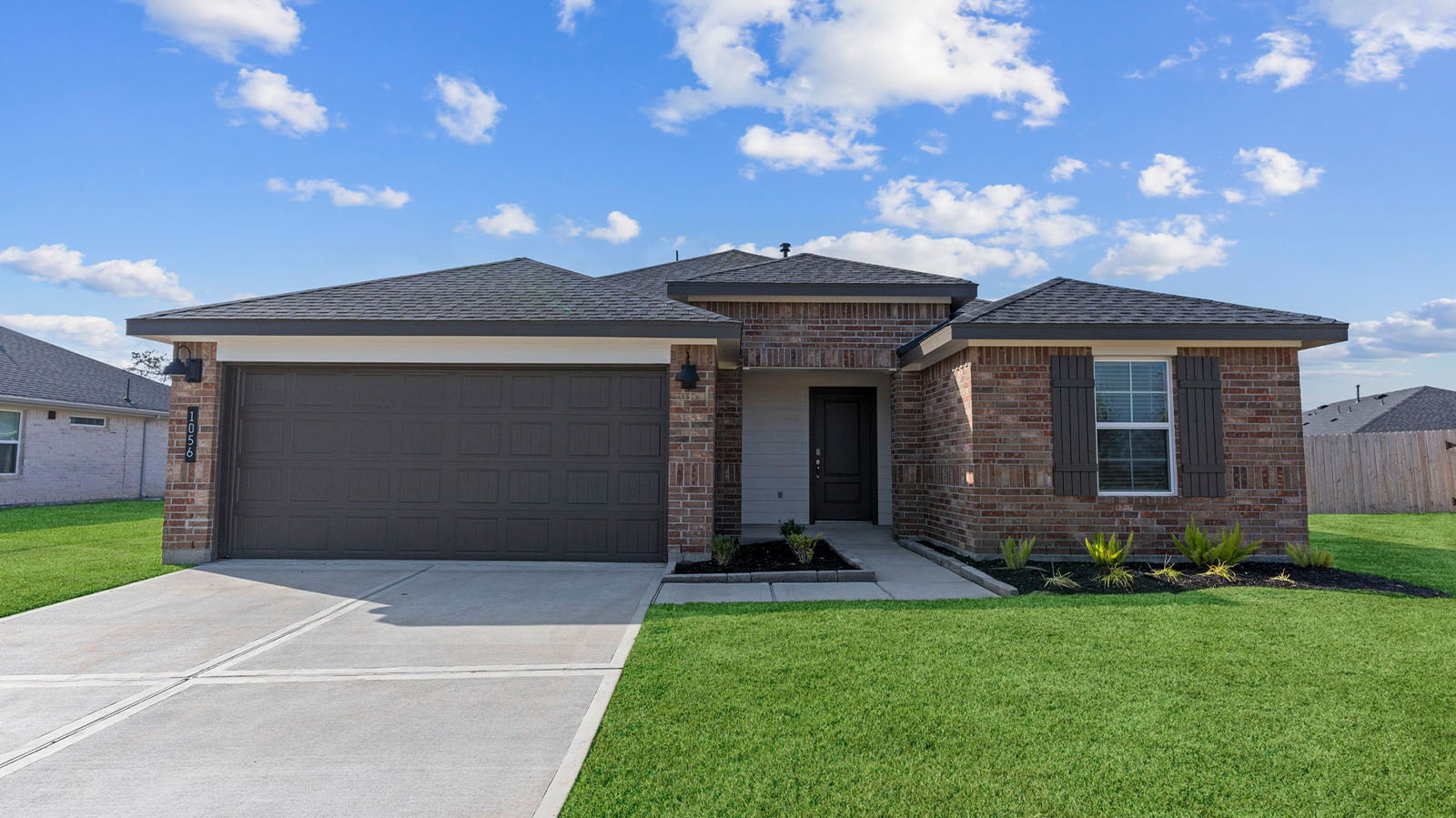 Newly built single story home with modern architecture, a double garage, and landscaped front yard.