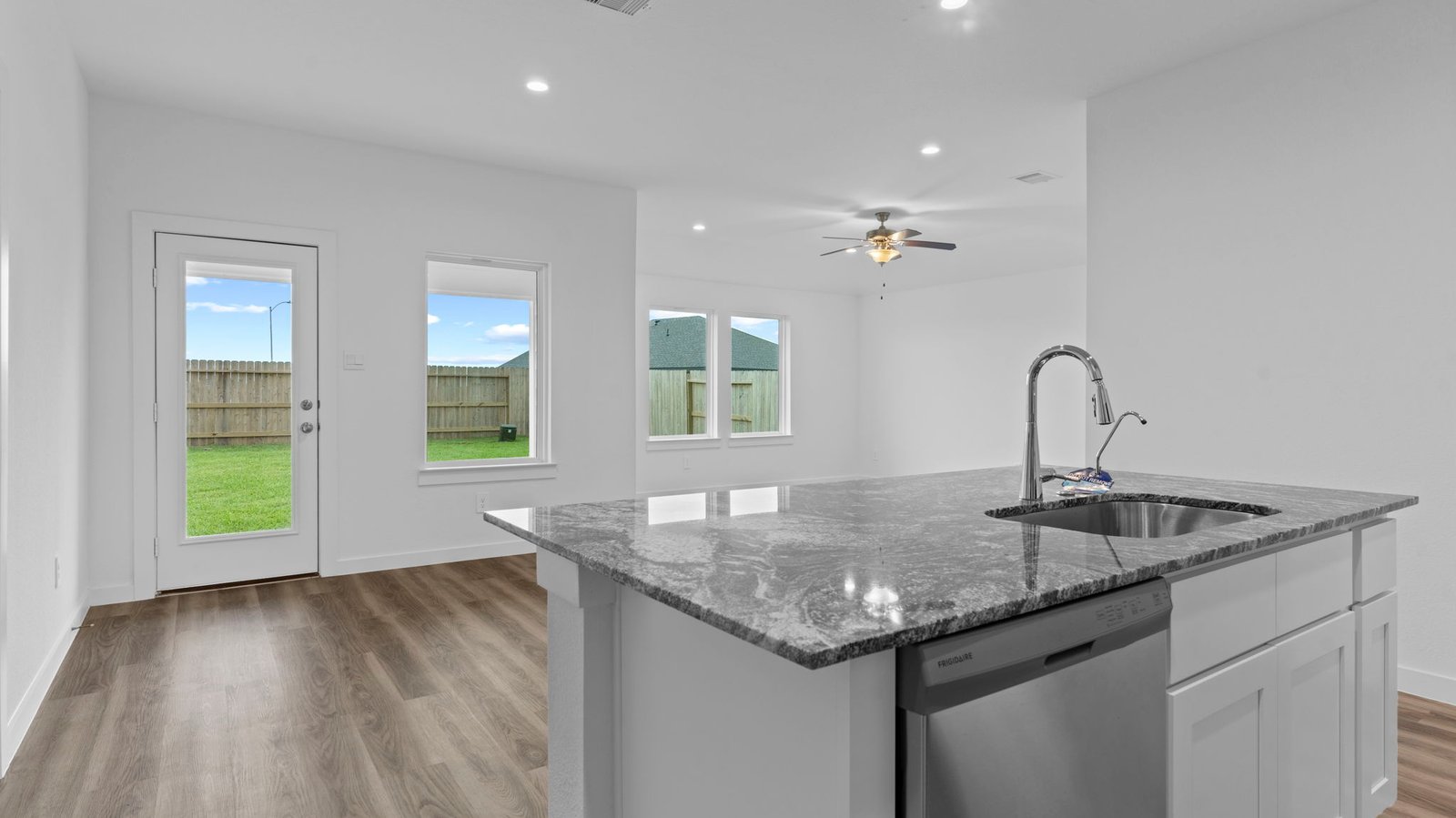 An open concept kitchen with an island with bar seating and access to the living and dining areas.