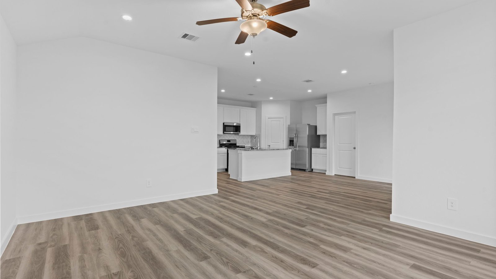 A well-organized living room that includes a kitchen and dining area, creating a warm and welcoming environment for gatherings.