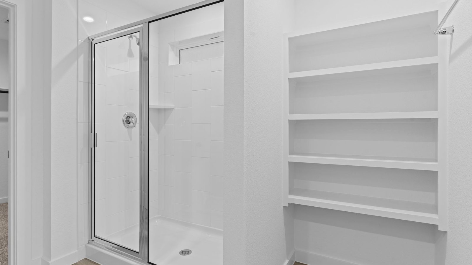 Modern primary bathroom with double vanities, quartz countertops, and a glass-enclosed shower with a walk-in closet.