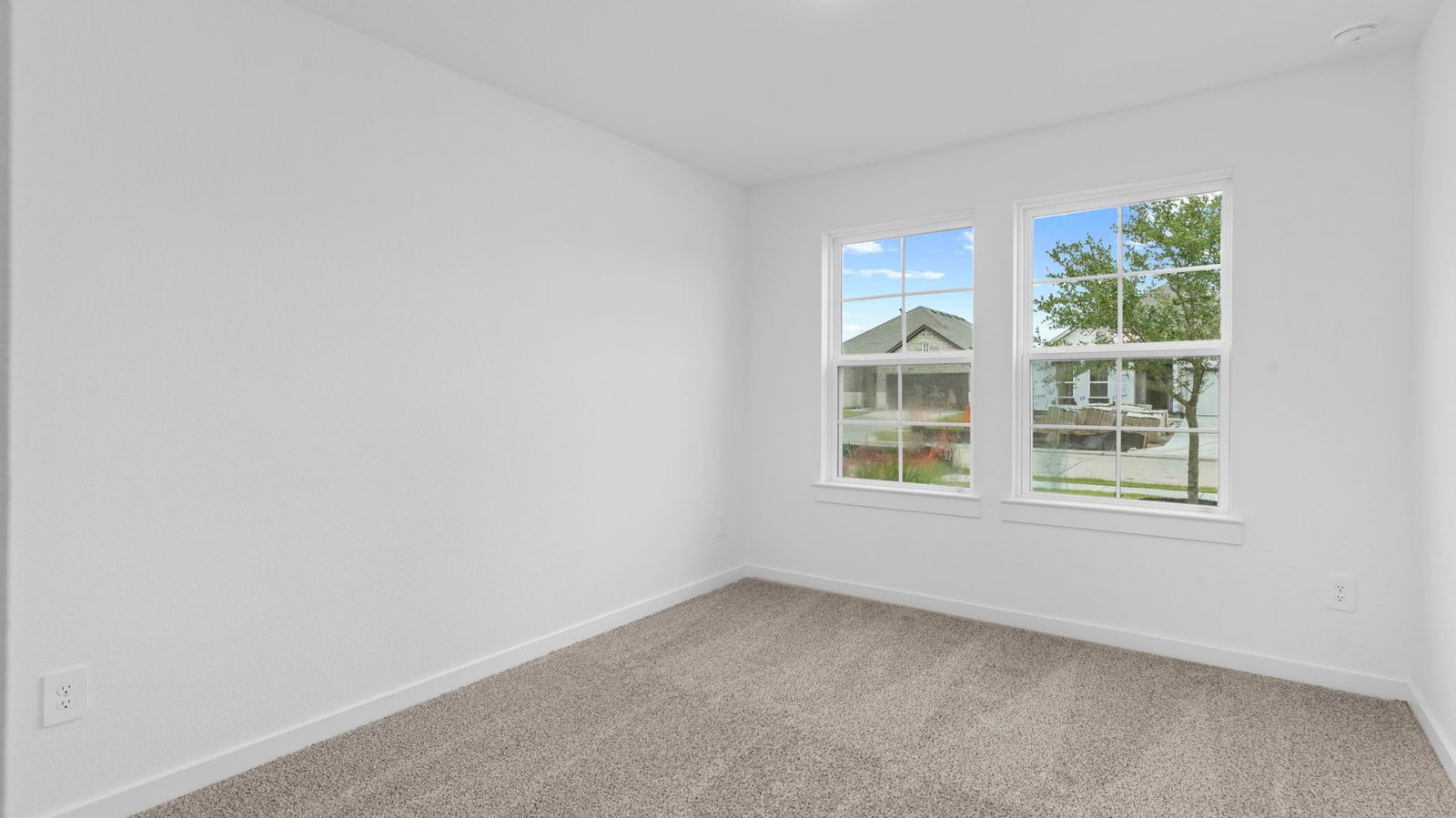 Comfortable guest bedroom featuring neutral-toned walls, carpeted flooring, and a separate closet.