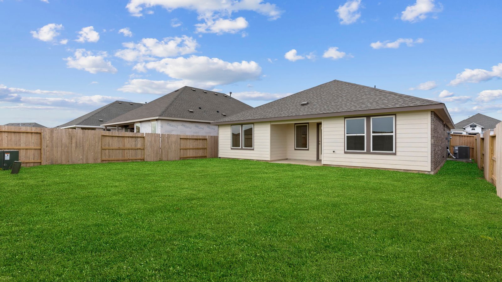 Outdoor covered patio with seating area overlooking a well-maintained lawn, perfect for relaxation.