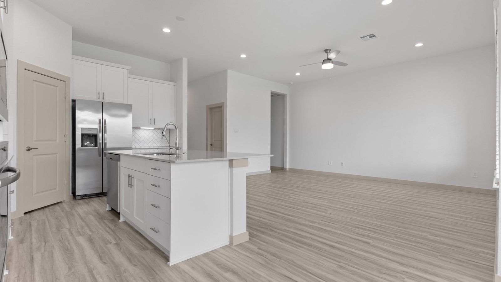 open concept kitchen and living room with multiple windows