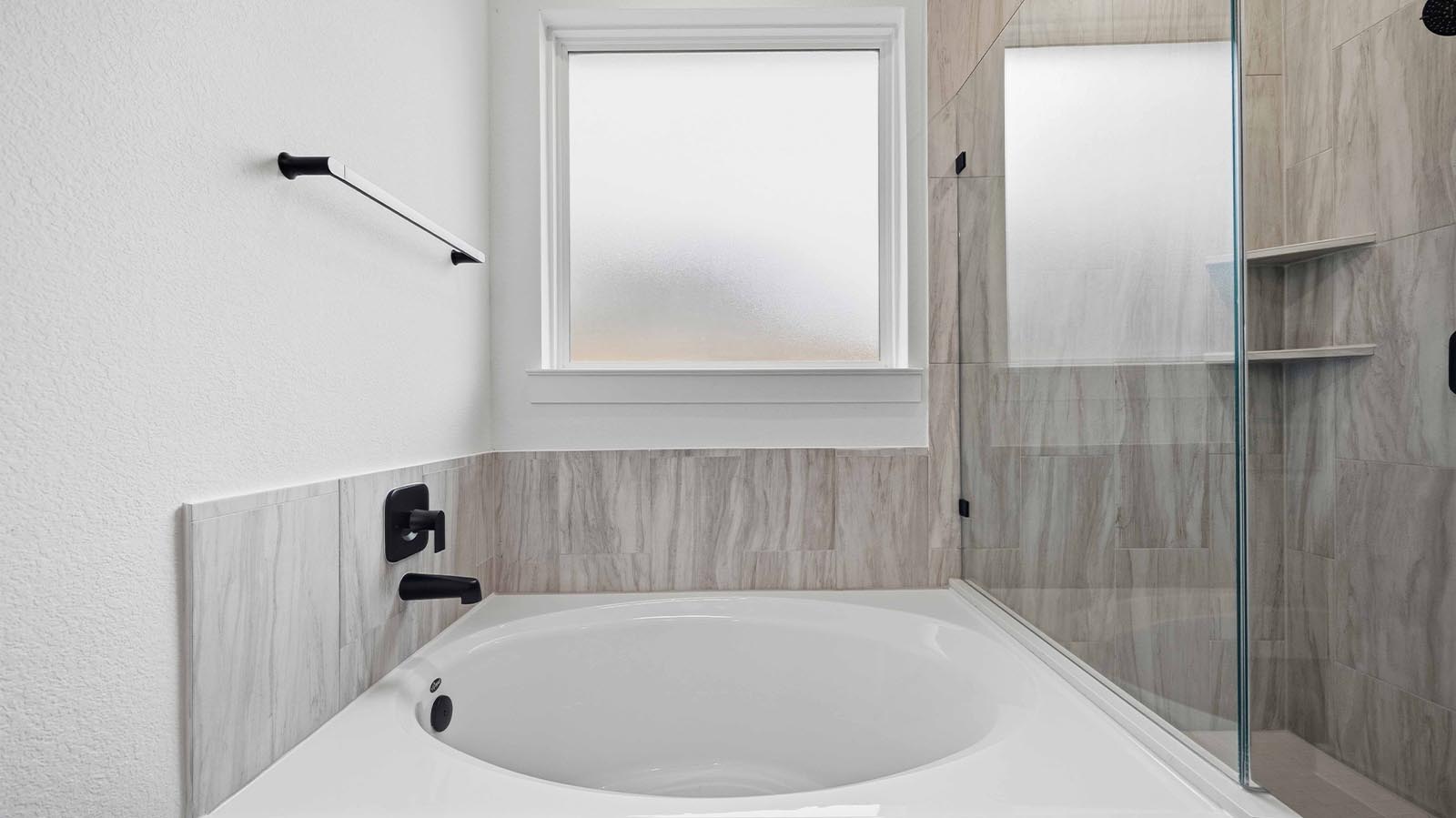 Primary bathroom with a glass-enclosed standing shower and separate soaking tub.
