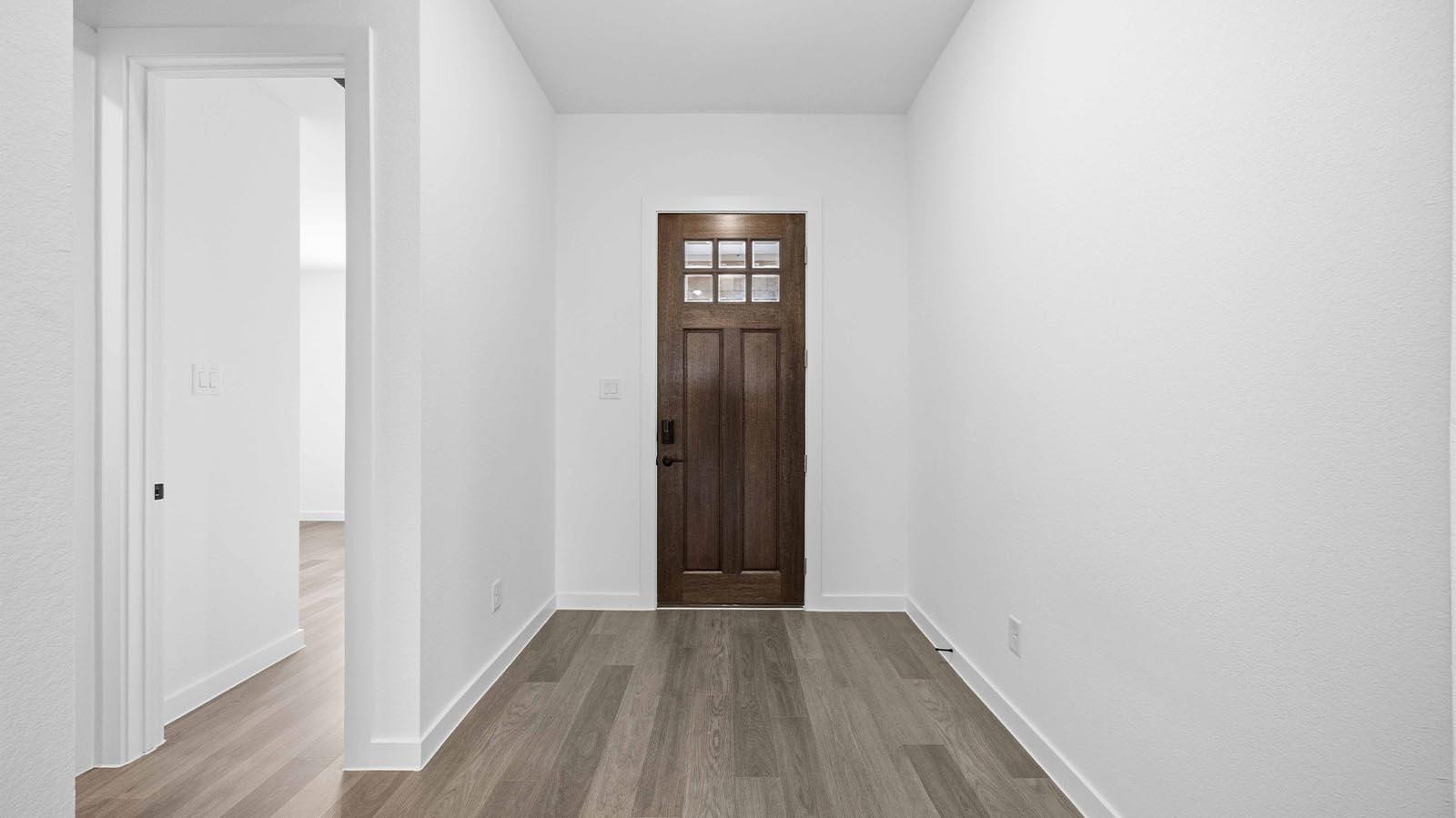 Entry hallway leading to living room and kitchen in the background.