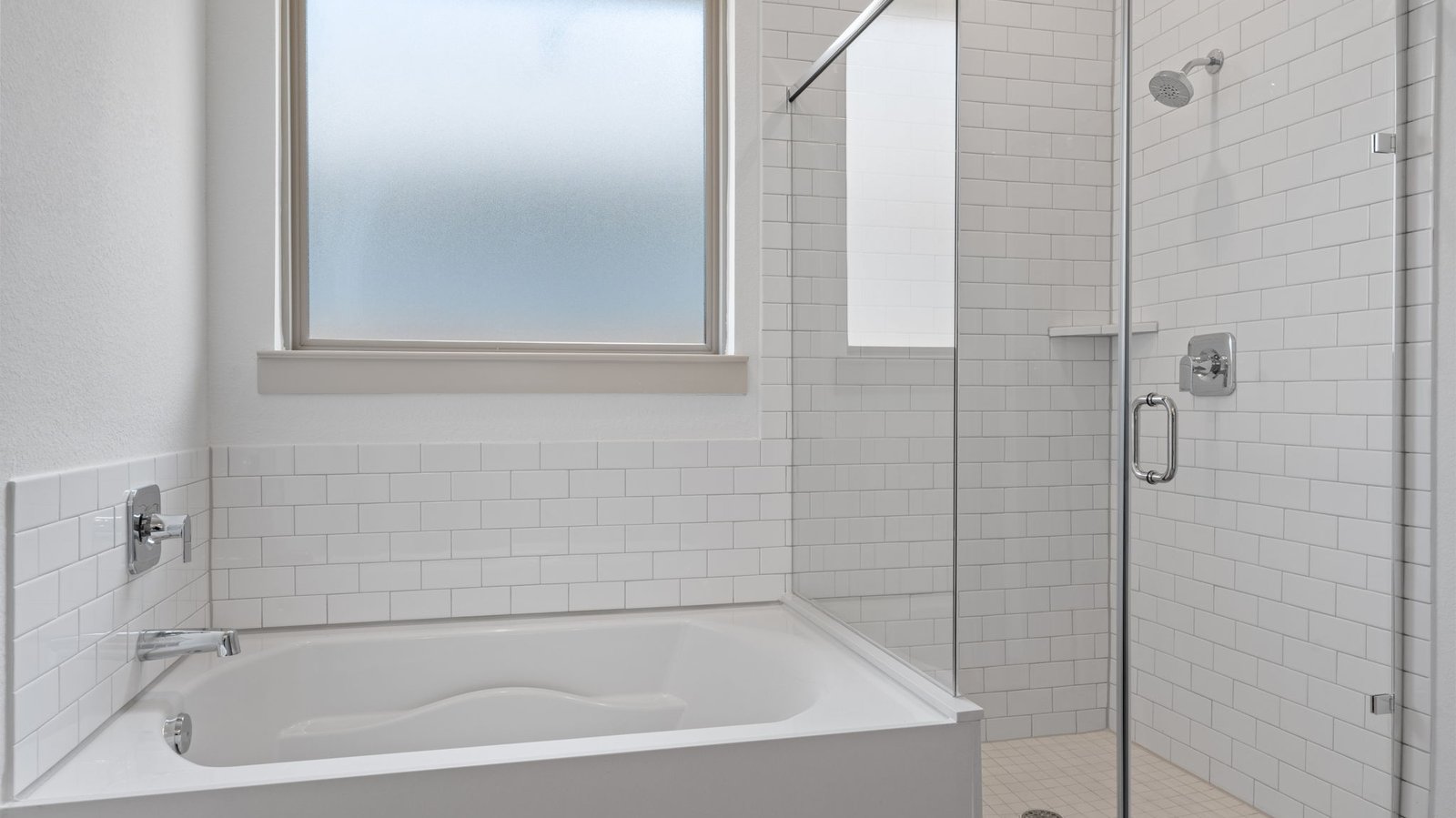 Master bath has  garden tub with white subway tile, an opaque window and a white subway tile walk-in shower with a glass door.