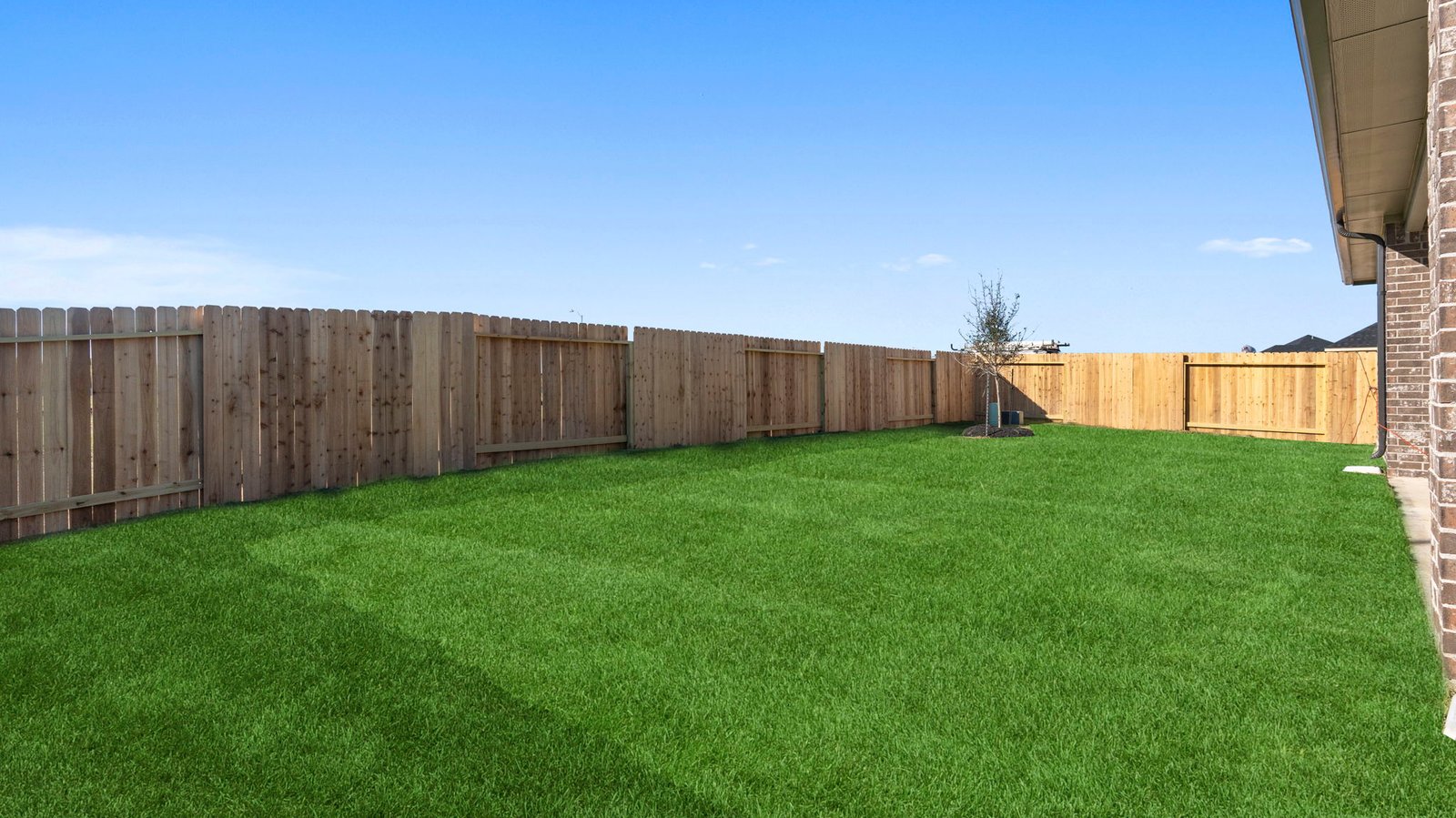 Outdoor covered patio with seating area overlooking a well-maintained lawn, perfect for relaxation.
