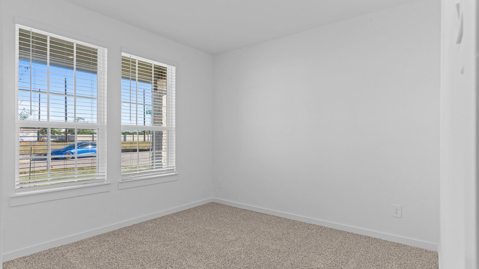 A bedroom shown as an at home office with a bright window allowing natural light to enter.