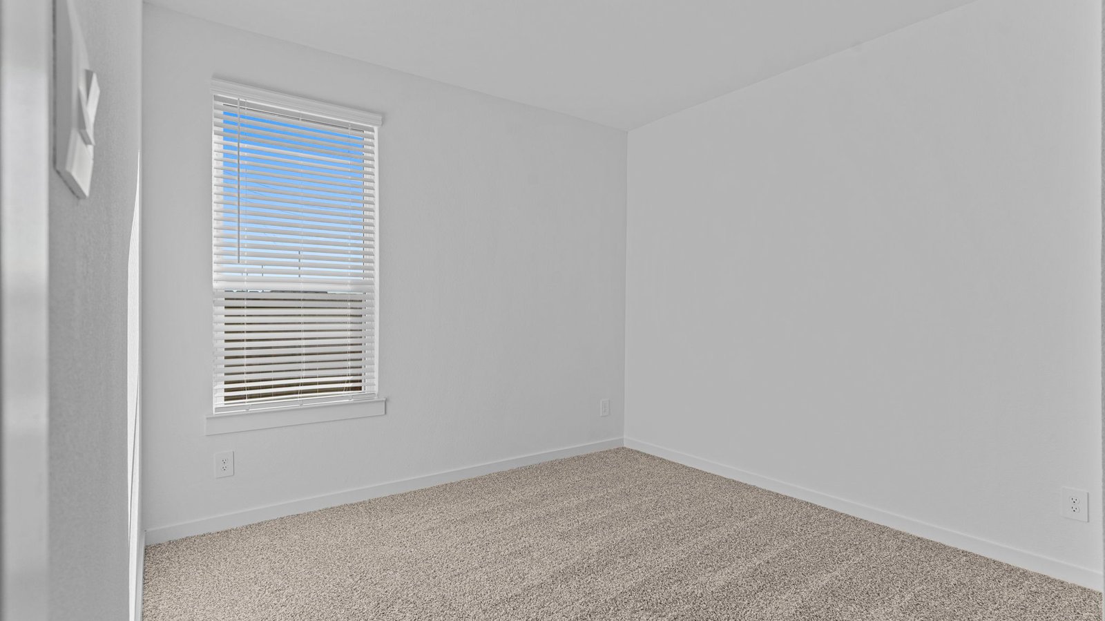Comfortable guest bedroom featuring neutral-toned walls, carpeted flooring, and a separate closet.