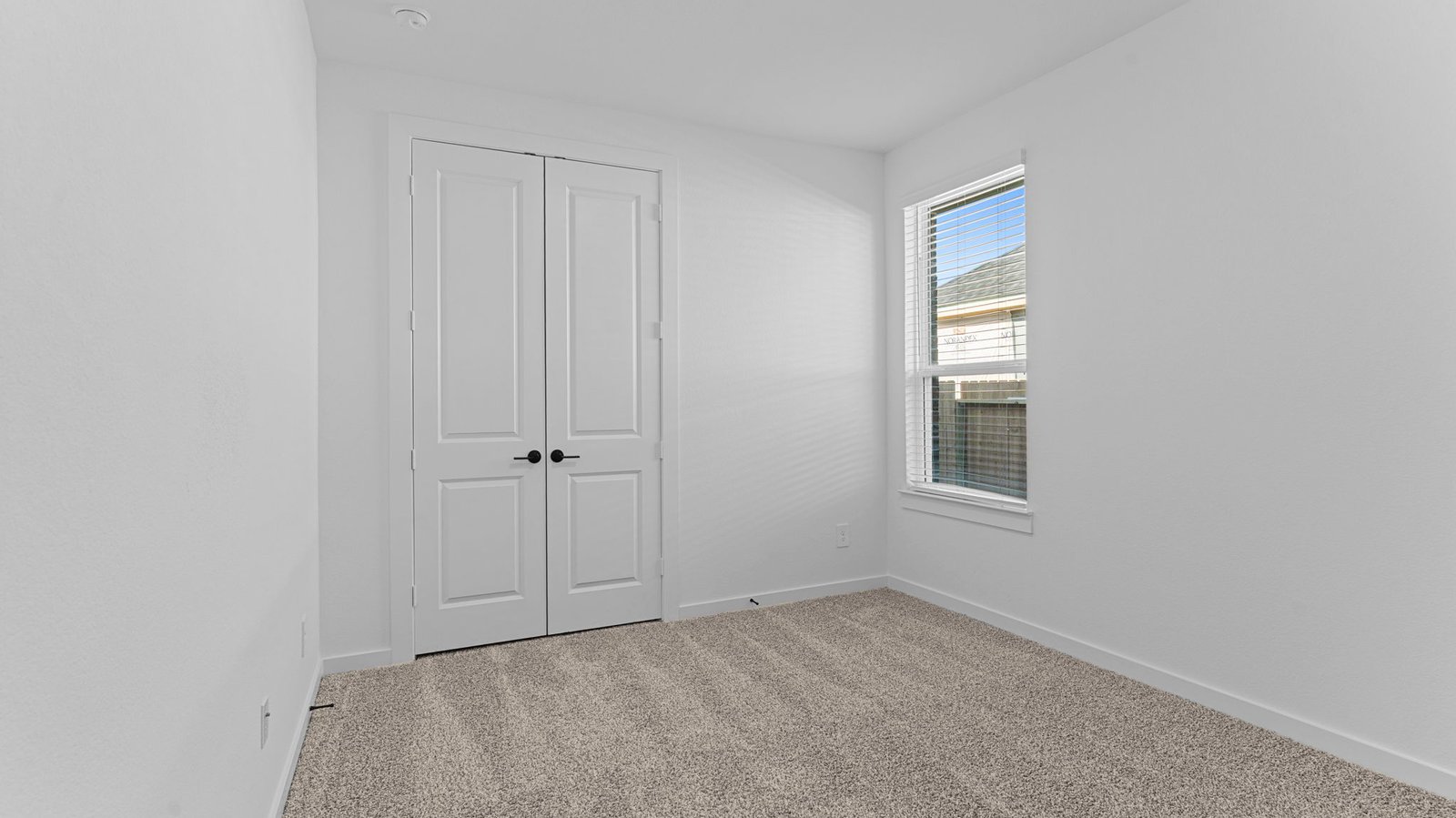 A third bedroom with neutral walls, plush carpet flooring and a separate closet.