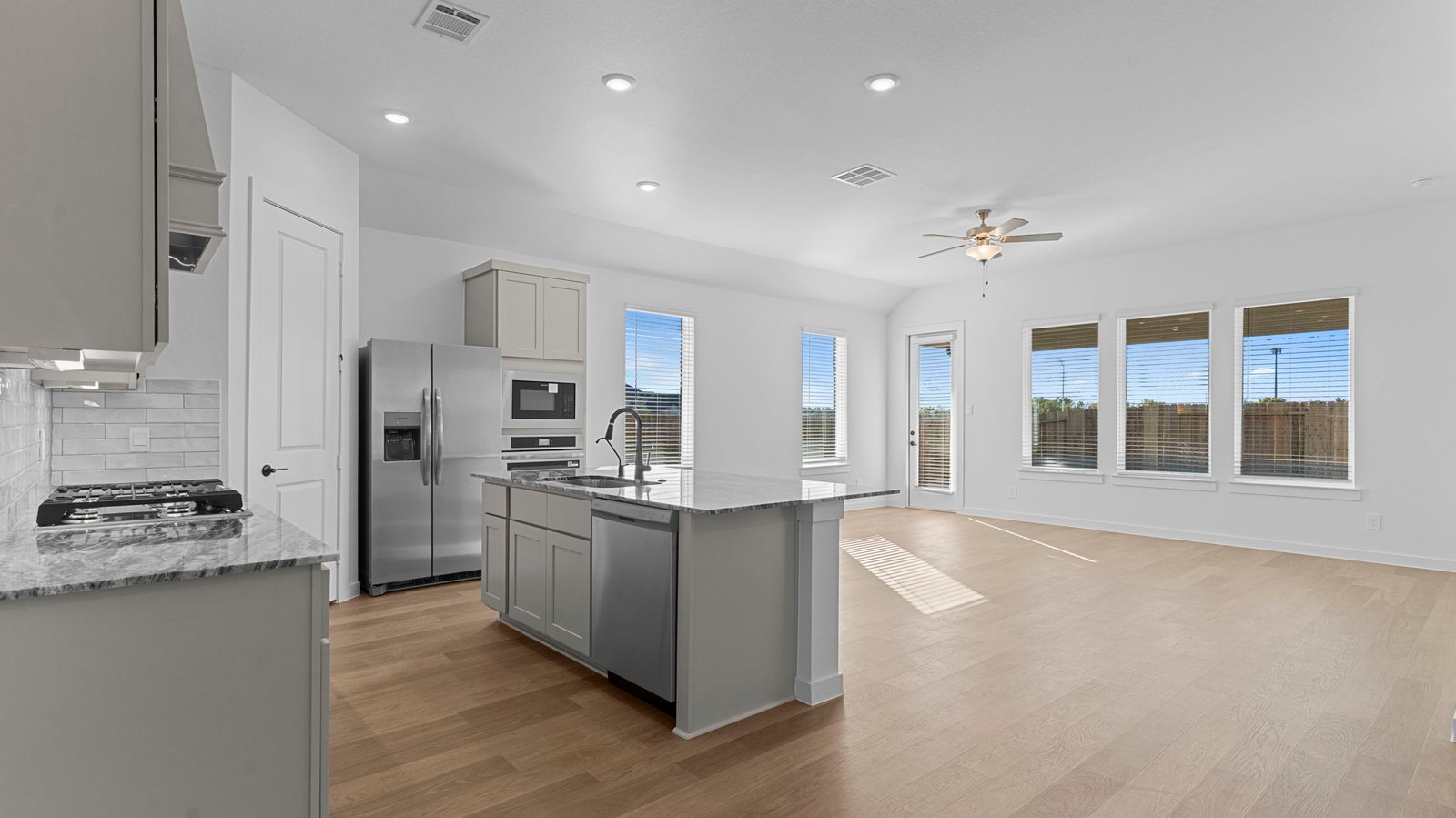 An open concept kitchen with an island with bar seating and access to the living and dining areas.