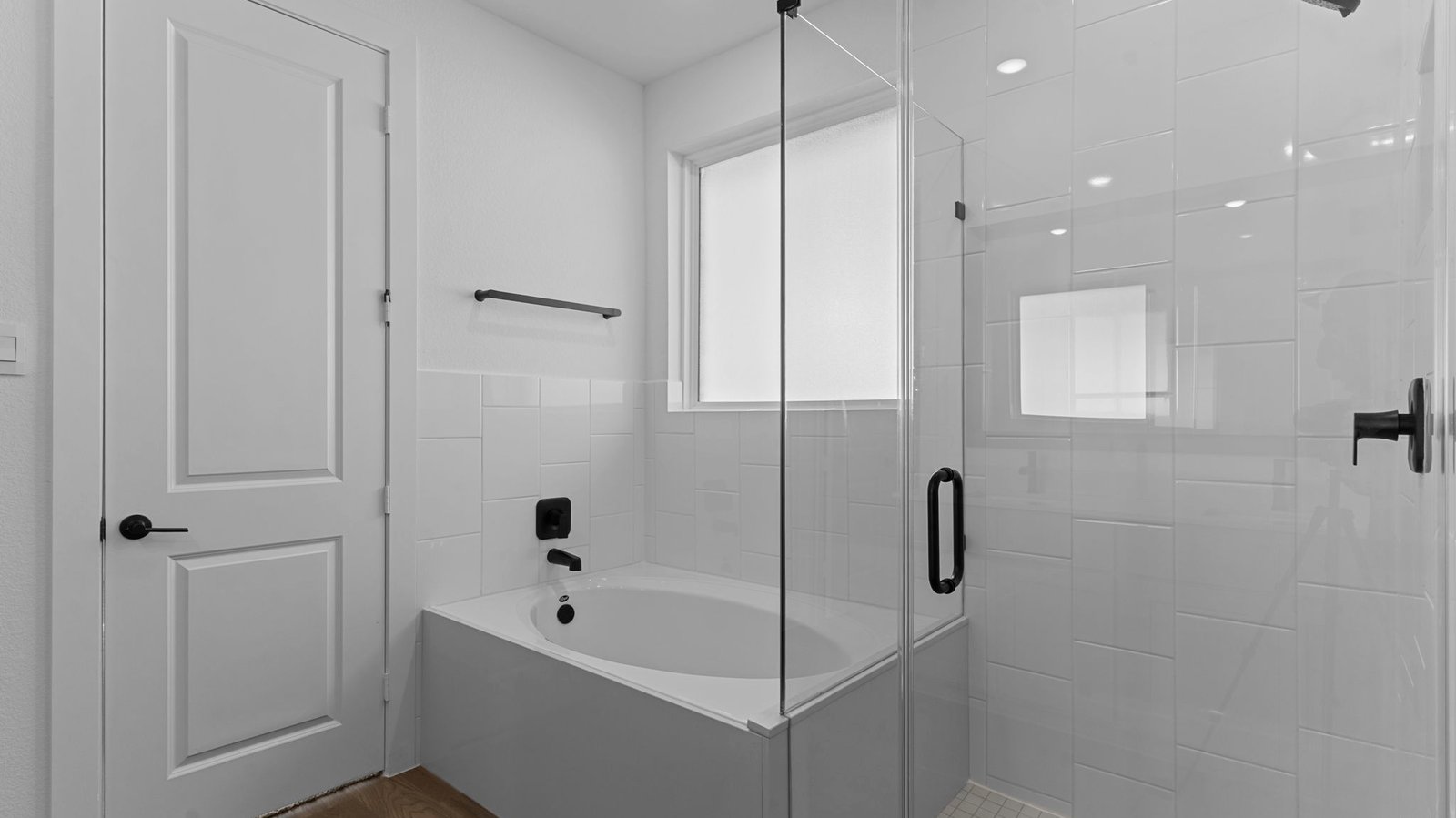 Primary bathroom with a glass-enclosed standing shower and separate soaking tub.