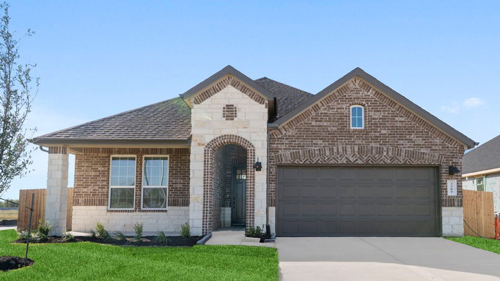 Newly built single story home with traditional architecture, a double garage, and landscaped front yard.
