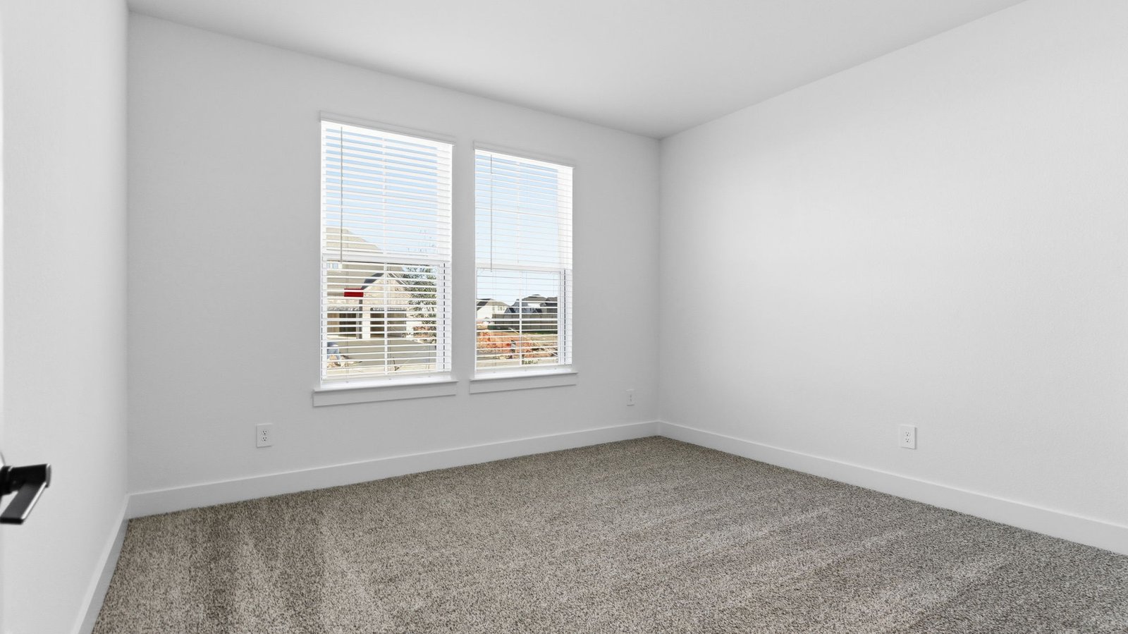 Comfortable guest bedroom featuring neutral-toned walls, carpeted flooring, and a separate closet.