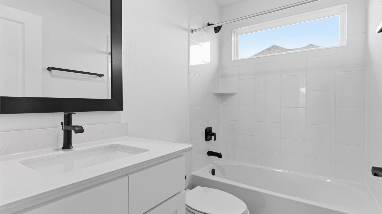 A well-designed bathroom equipped with quartz countertops, a standing tub, and a single vanity.