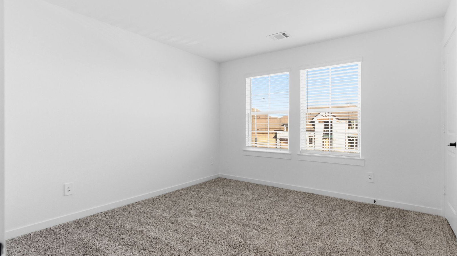 A third bedroom with neutral walls, plush carpet flooring and a separate closet.