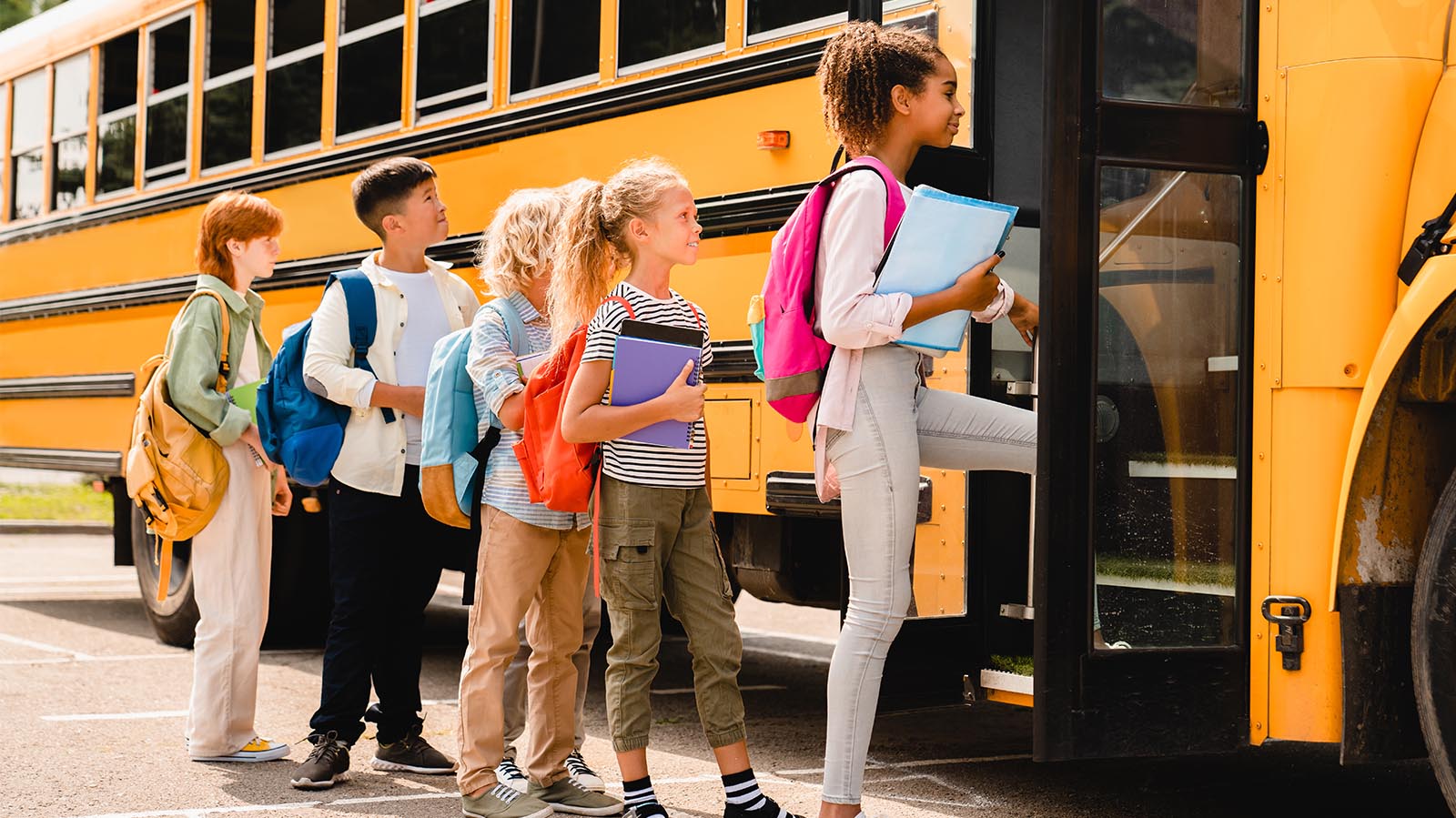 Children getting on a yellow school bus