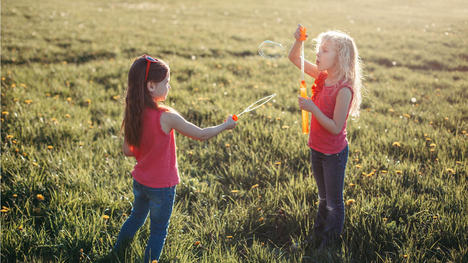 two little girls playing in a grassy field