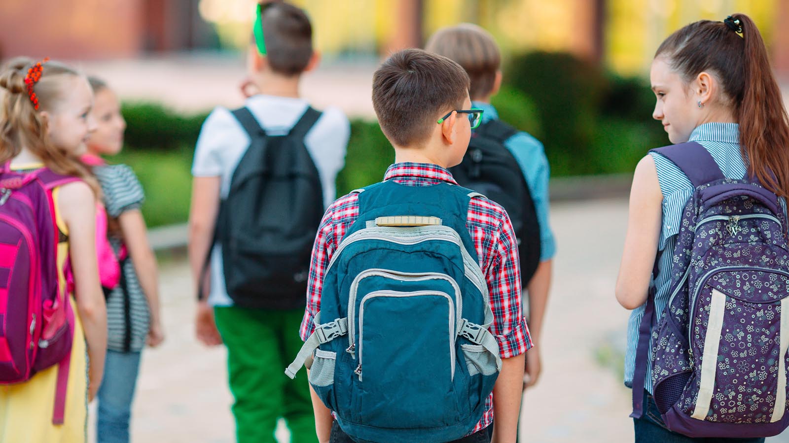 Children walking to school wearing backpacks