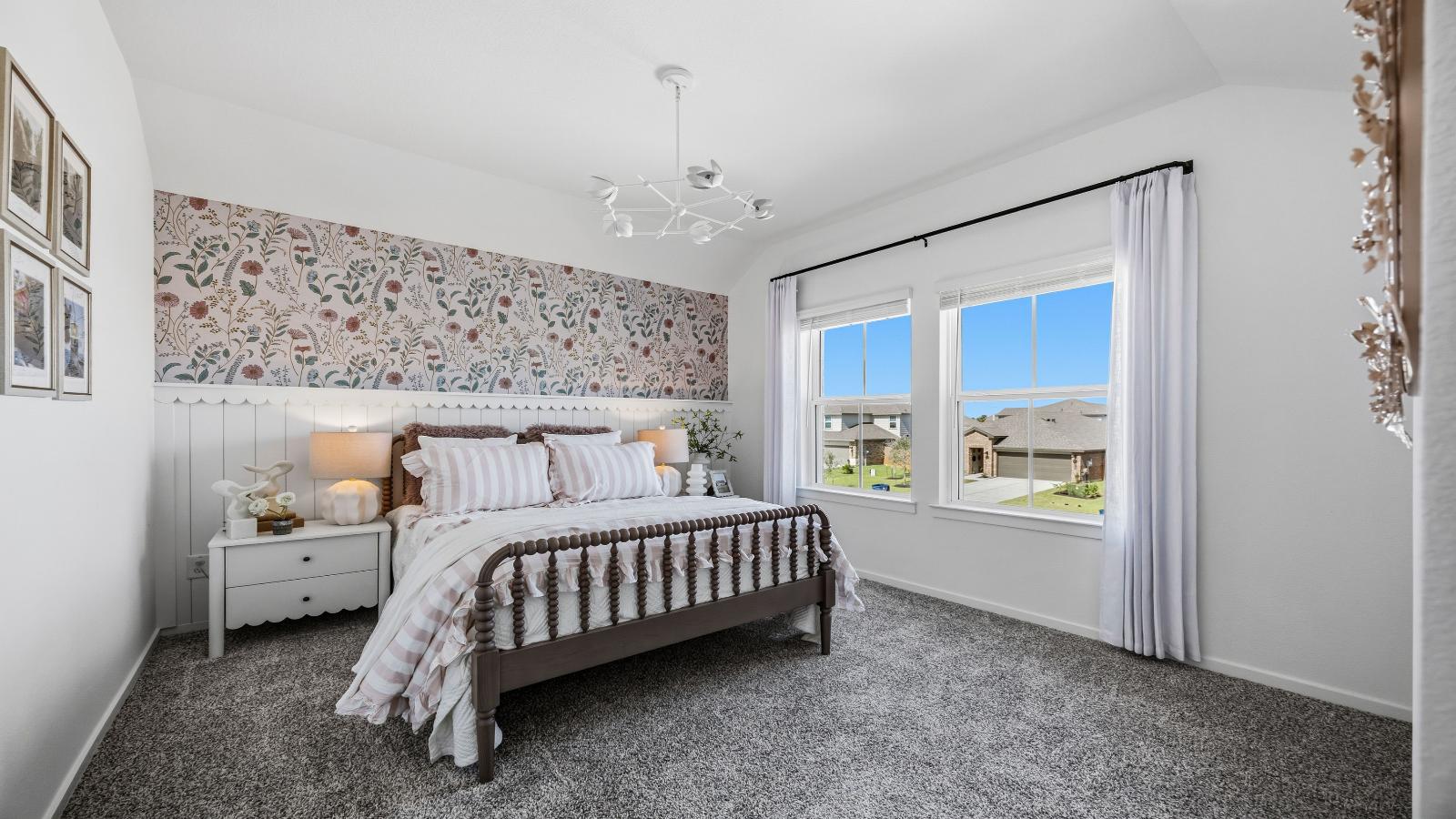 A vibrant bedroom showcasing a neatly made bed, a stylish dresser, and a playful painting that adds charm.