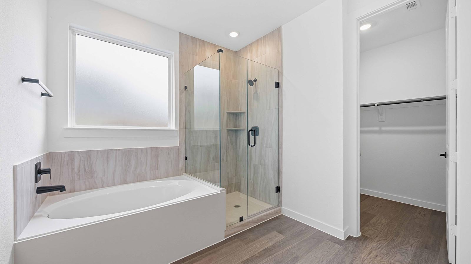 Primary bathroom with a glass-enclosed standing shower and separate soaking tub.