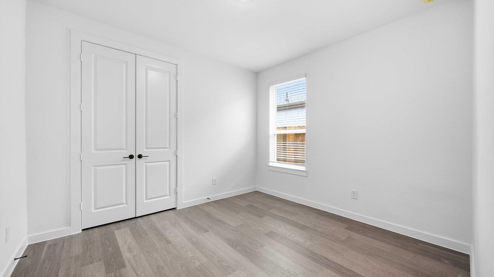Comfortable guest bedroom featuring neutral-toned walls, carpeted flooring, and a separate closet.