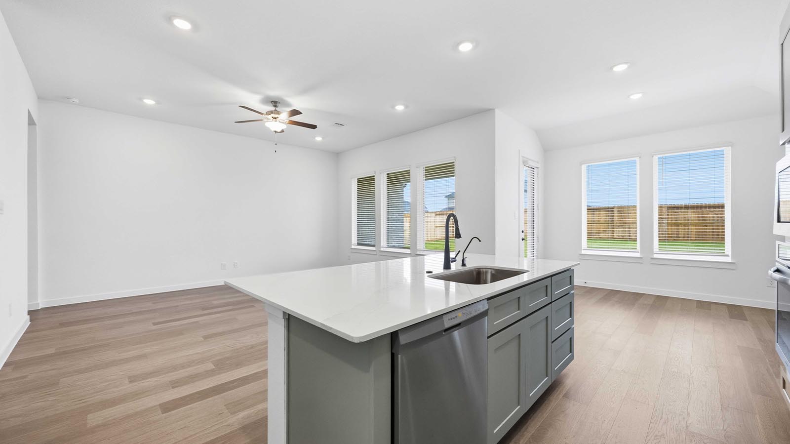 An open concept kitchen with an island with bar seating and access to the living and dining areas.