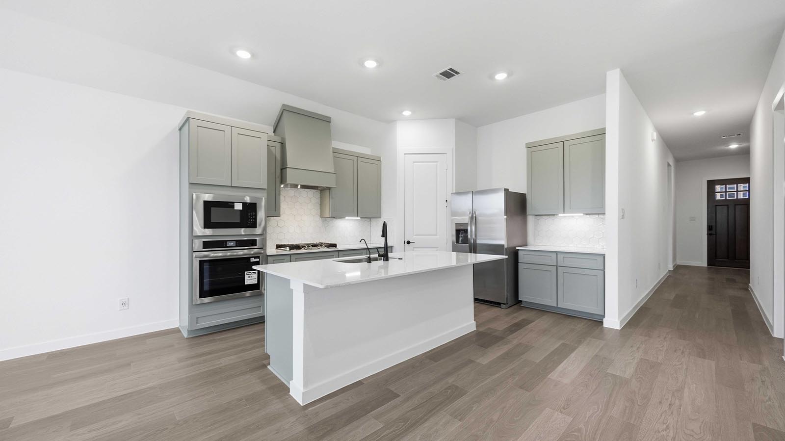 Bright and spacious kitchen with granite countertops, stainless steel appliances, and an island with bar seating.