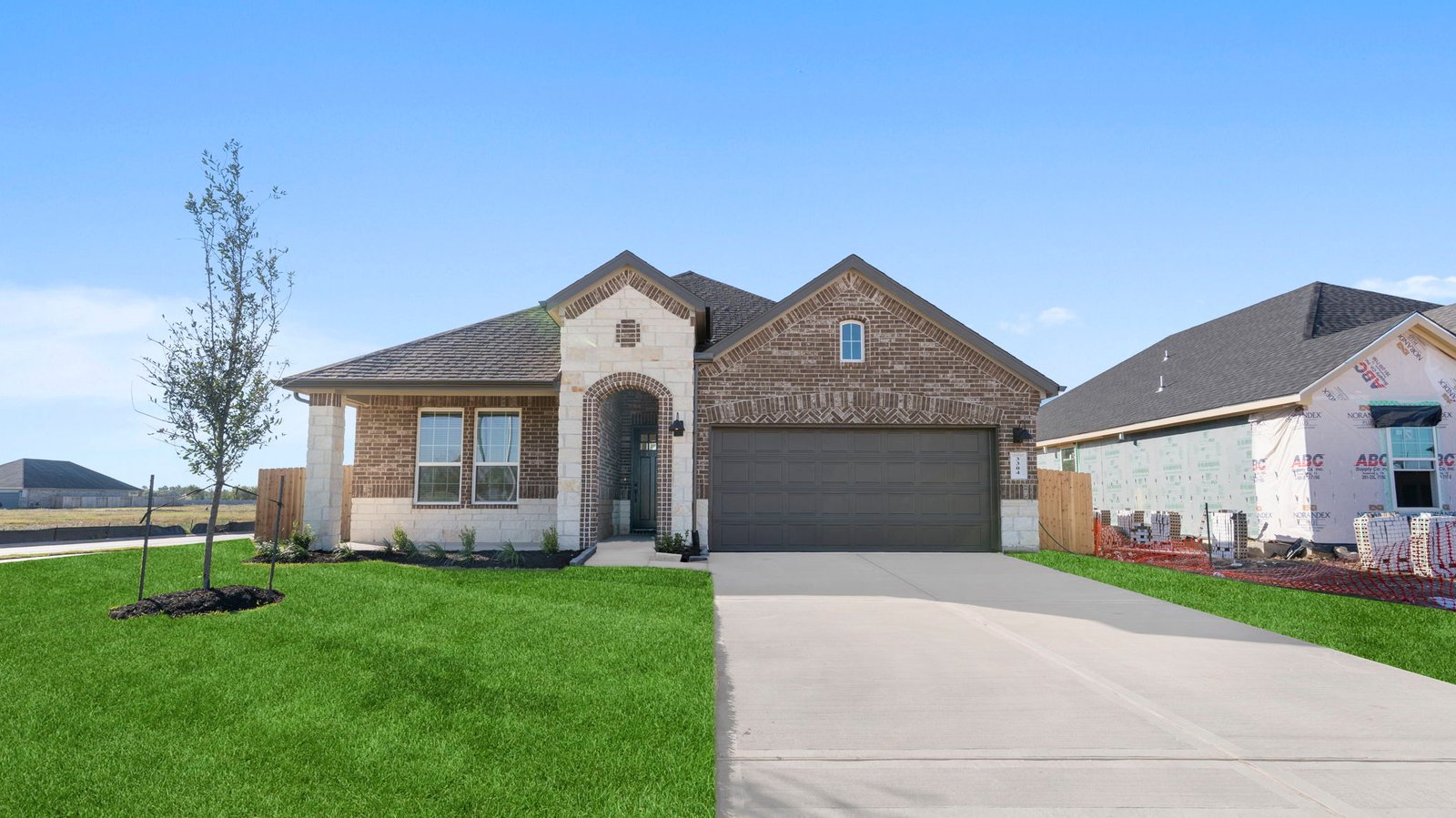 Newly built single story home with traditional architecture, a double garage, and landscaped front yard.
