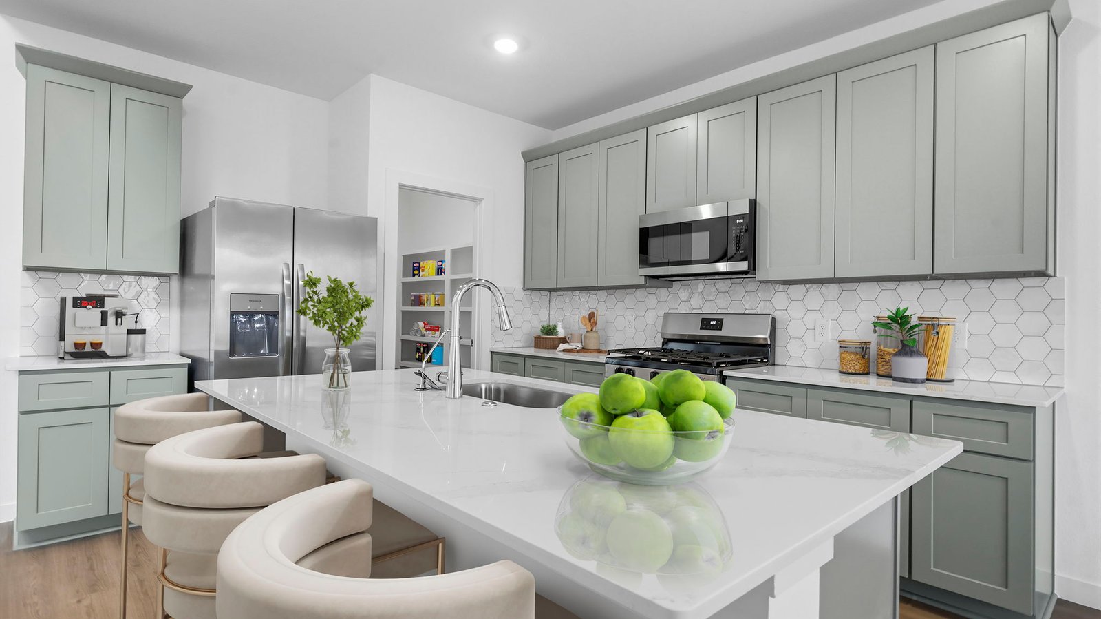 Bright and spacious kitchen with quartz countertops, stainless steel appliances, and an island with bar seating.