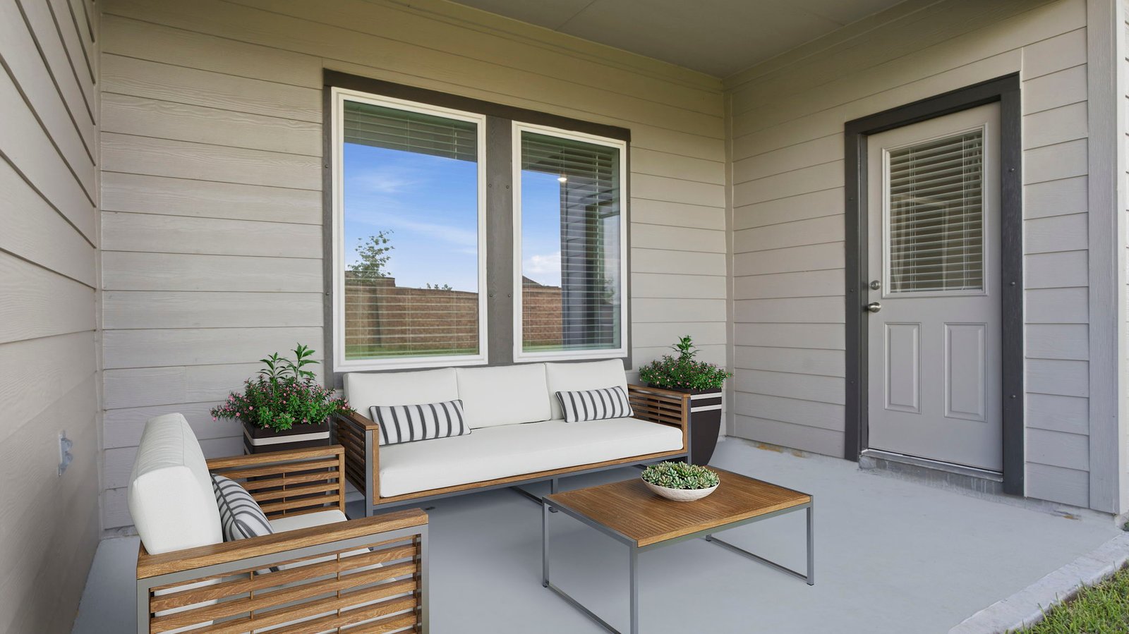 Outdoor covered patio with seating area overlooking a well-maintained lawn, perfect for relaxation.