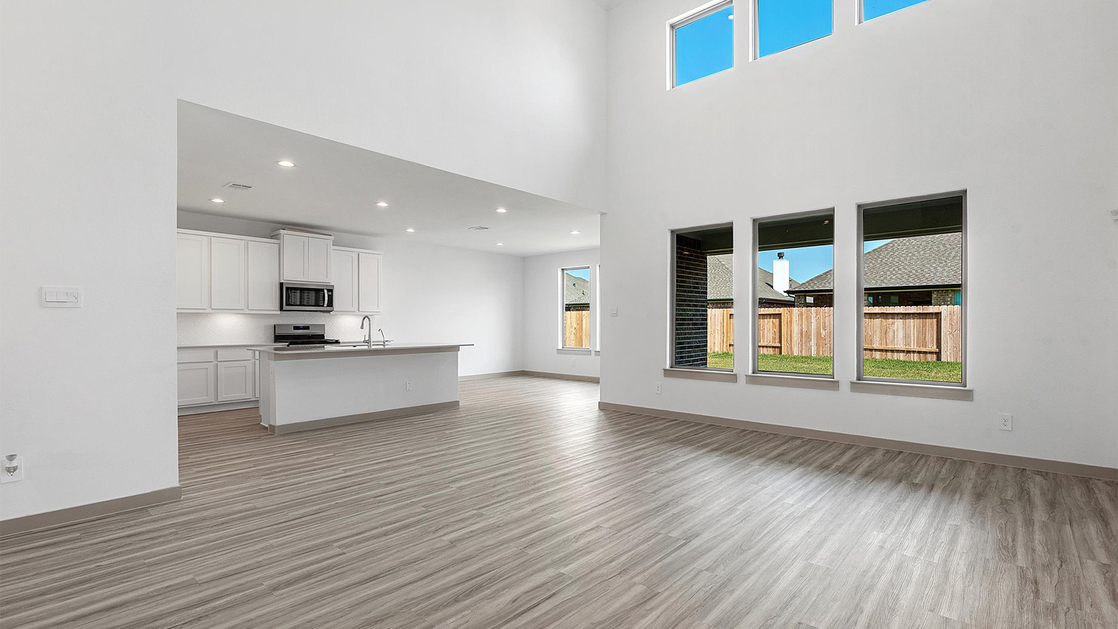 A well-organized living room that includes a kitchen and dining area, creating a warm and welcoming environment for gatherings.