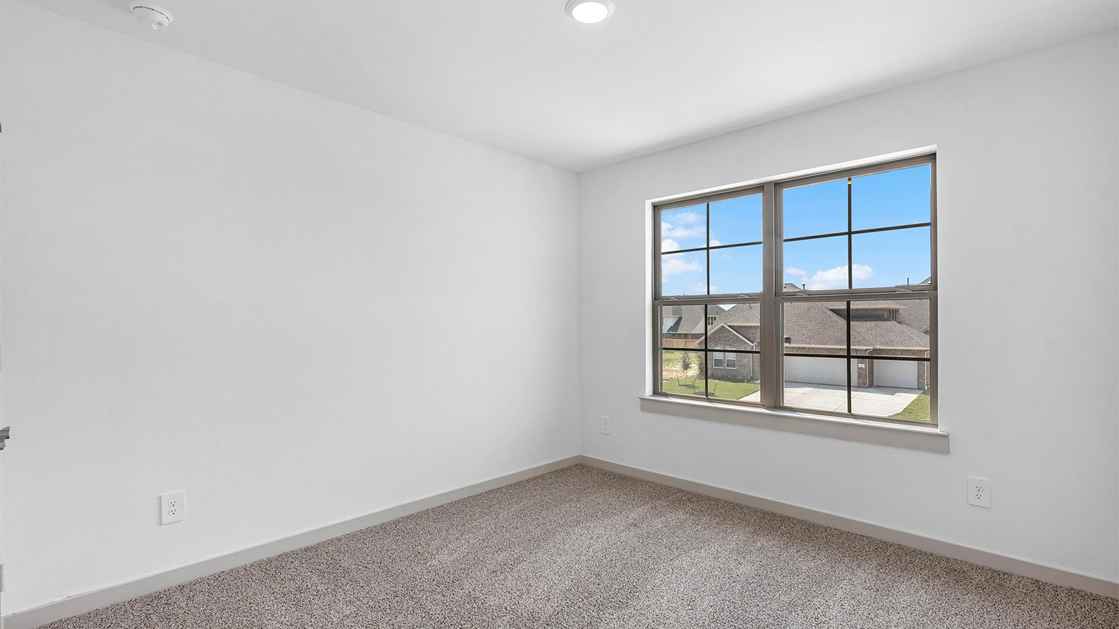 Comfortable guest bedroom featuring neutral-toned walls, carpeted flooring, and a separate closet.