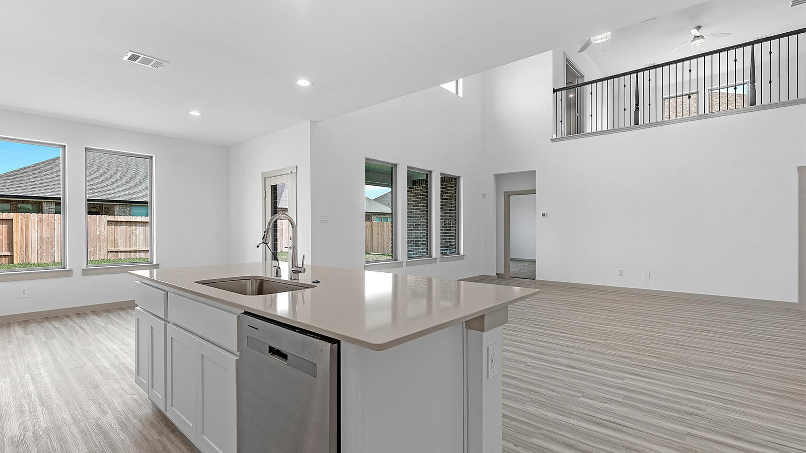 An open concept kitchen with an island with bar seating and access to the living and dining areas.