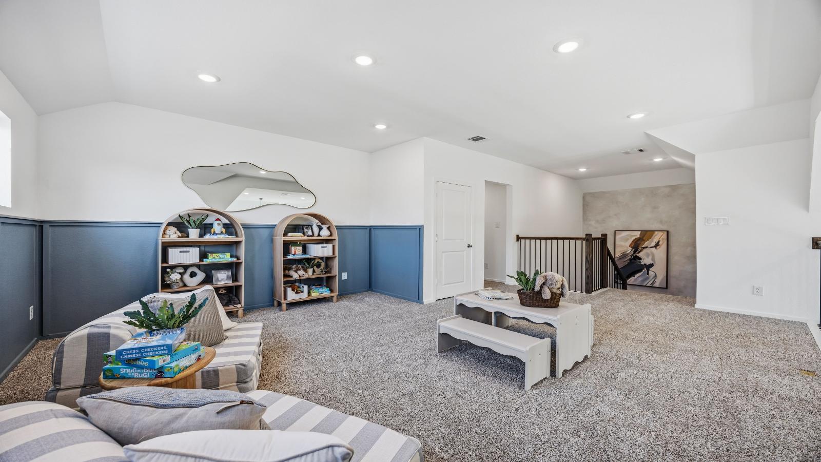 A spacious upstairs living area with plenty of natural light from windows overlooking side of the home