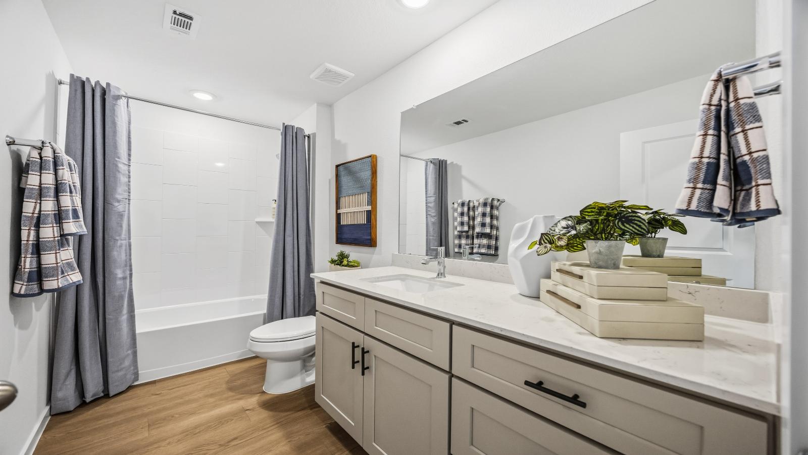 A well-designed bathroom equipped with quartz countertops, a standing tub, and a double vanity.
