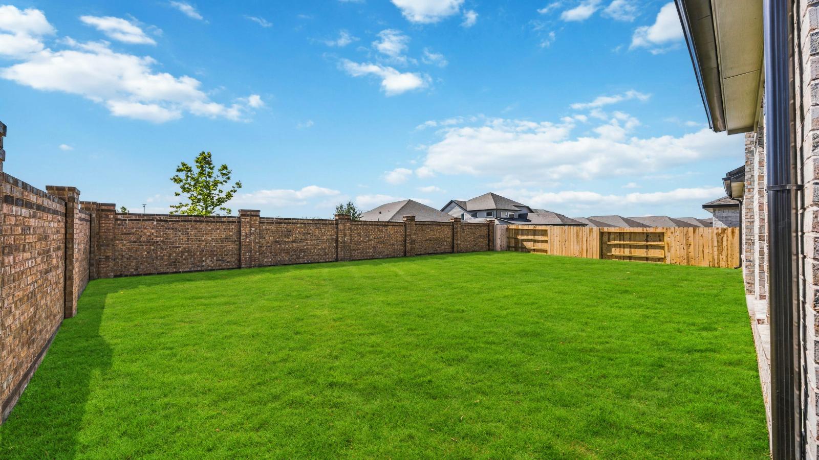 Large fenced-in backyard with a covered patio, perfect for outdoor entertaining.
