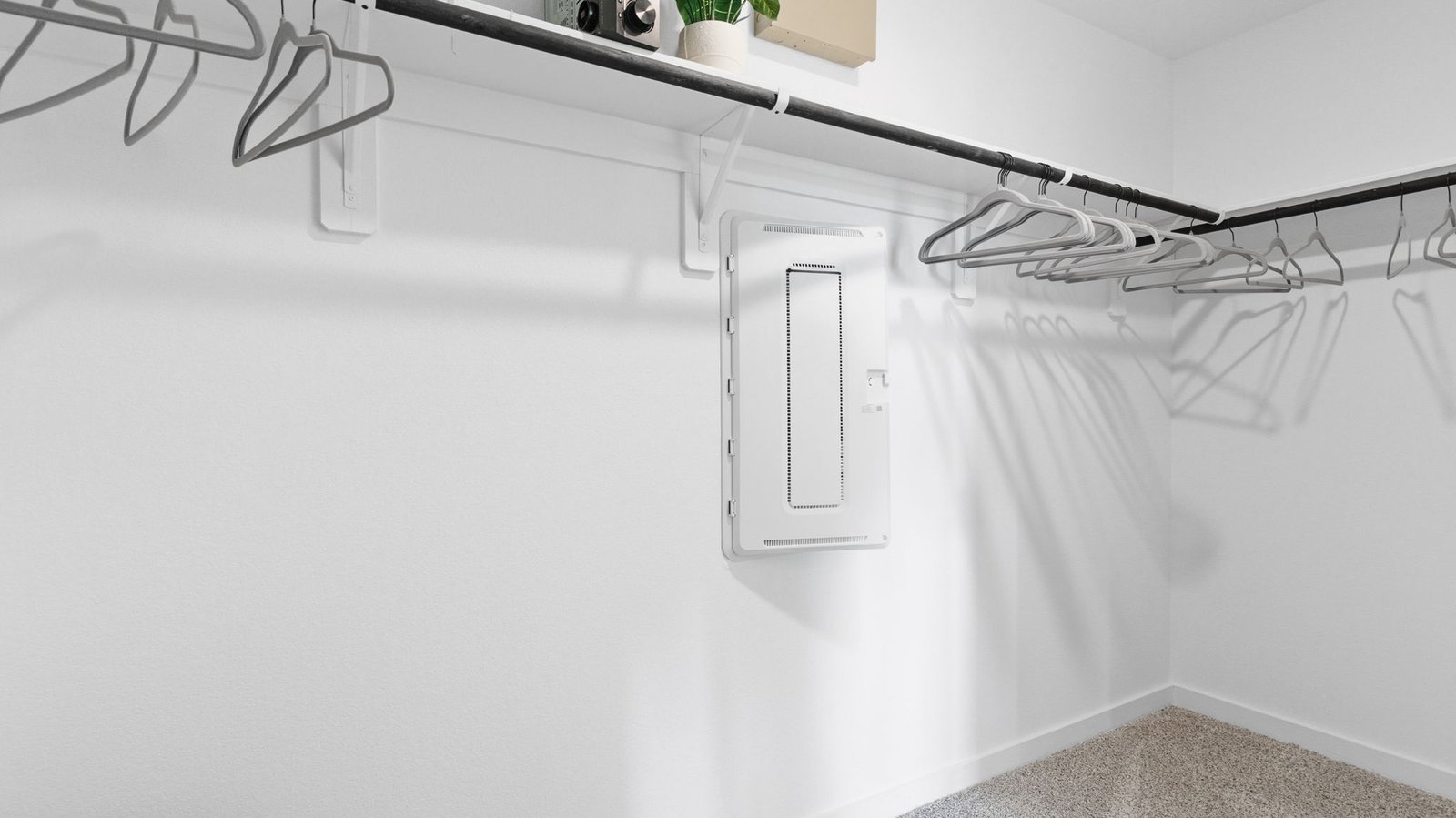 A spacious walk-in closet off the primary bathroom with multiple hanging rods, and shelves for maximum storage capabilities.