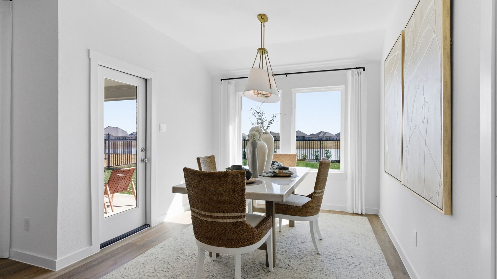 Formal dining room with large windows, vinyl wood floors, and view of the backyard.