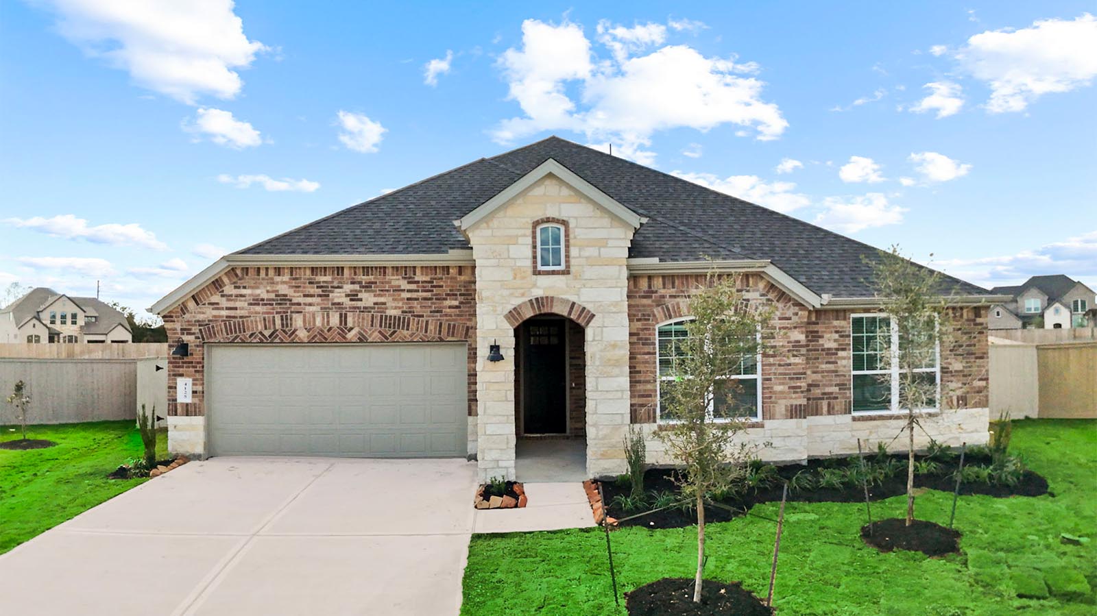 Newly built single story home with traditional architecture, a double garage, and landscaped front yard.