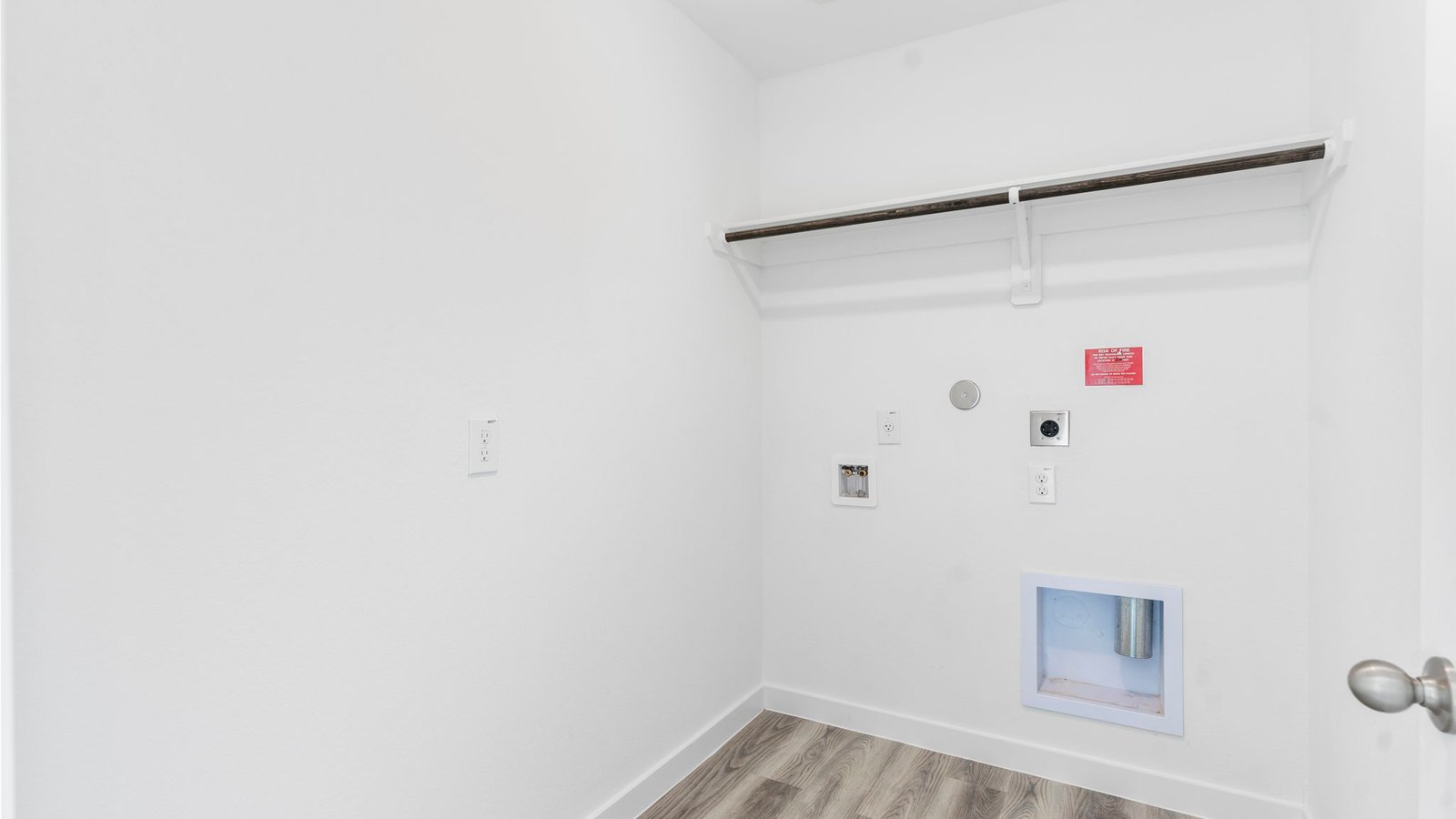 Spacious laundry room with washer and dryer connections, hanging rod, and vinyl wood flooring