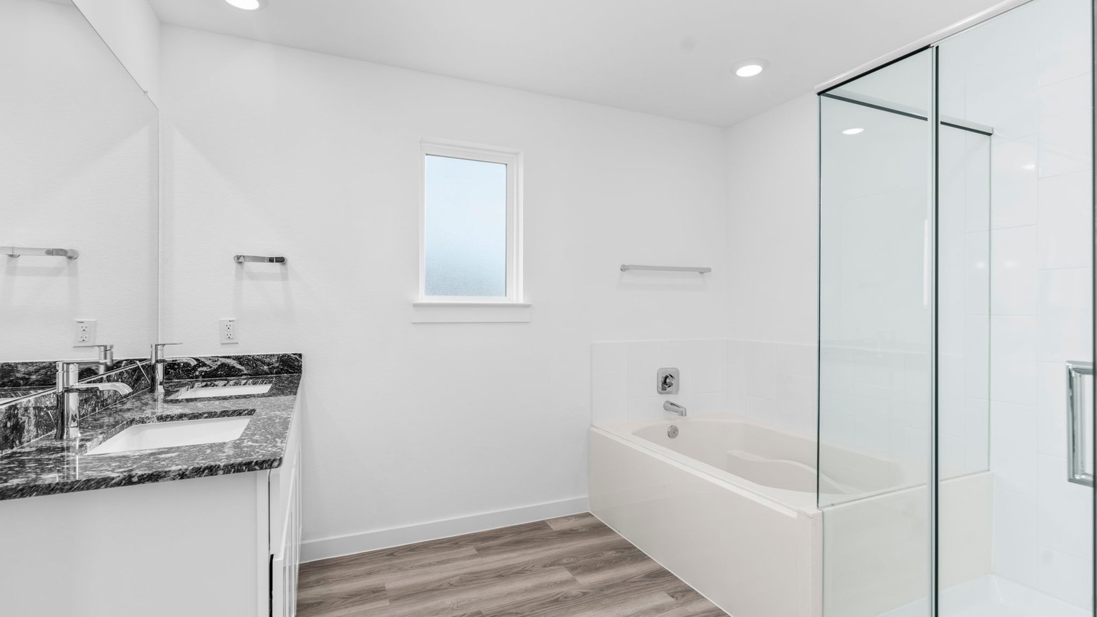 Primary bathroom with a glass-enclosed standing shower and separate soaking tub.