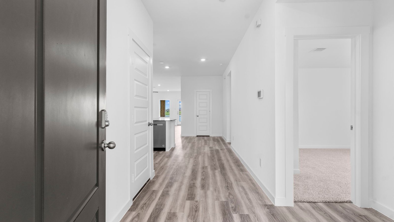 Entry hallway leading to living room and kitchen in the background.