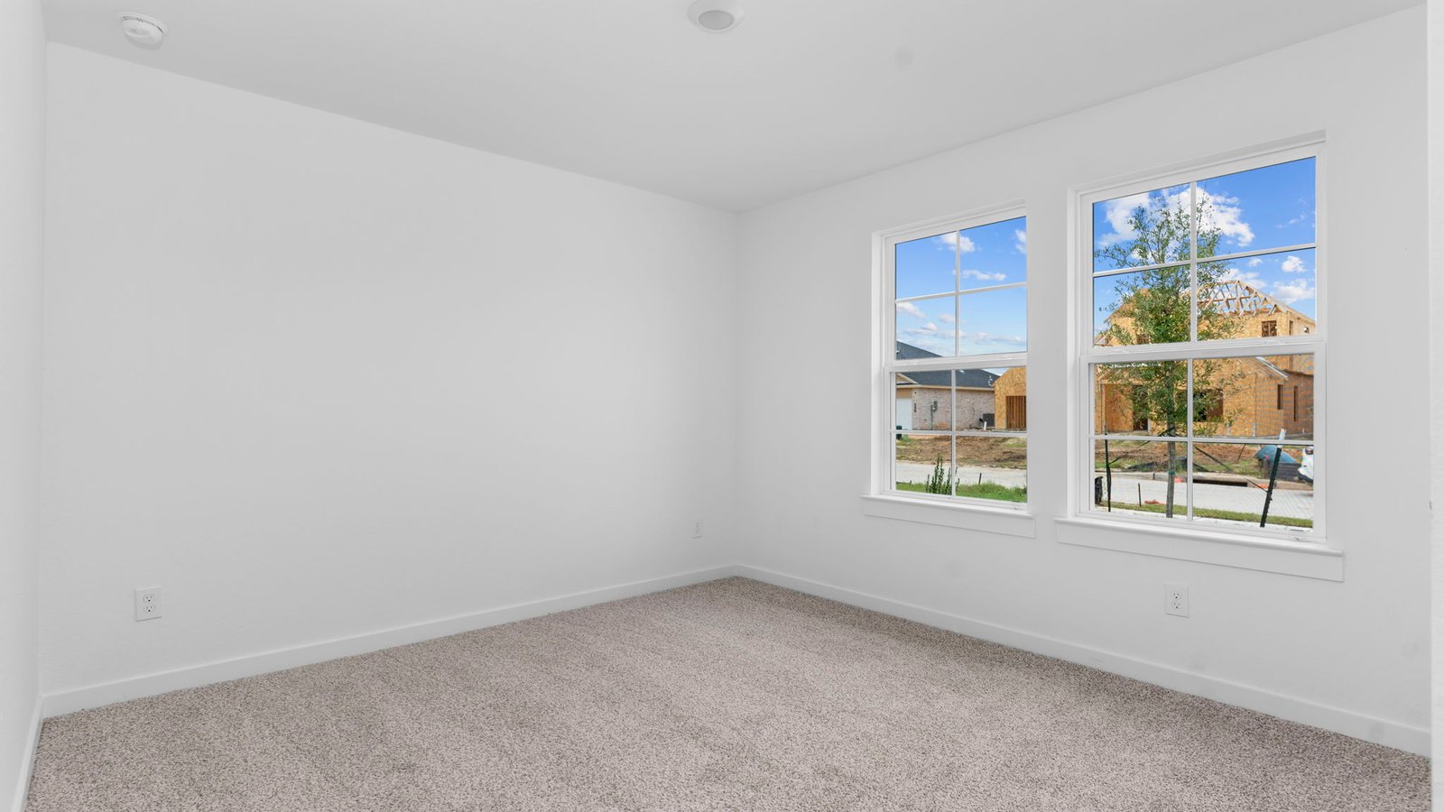 Comfortable guest bedroom featuring neutral-toned walls, carpeted flooring, and a separate closet.