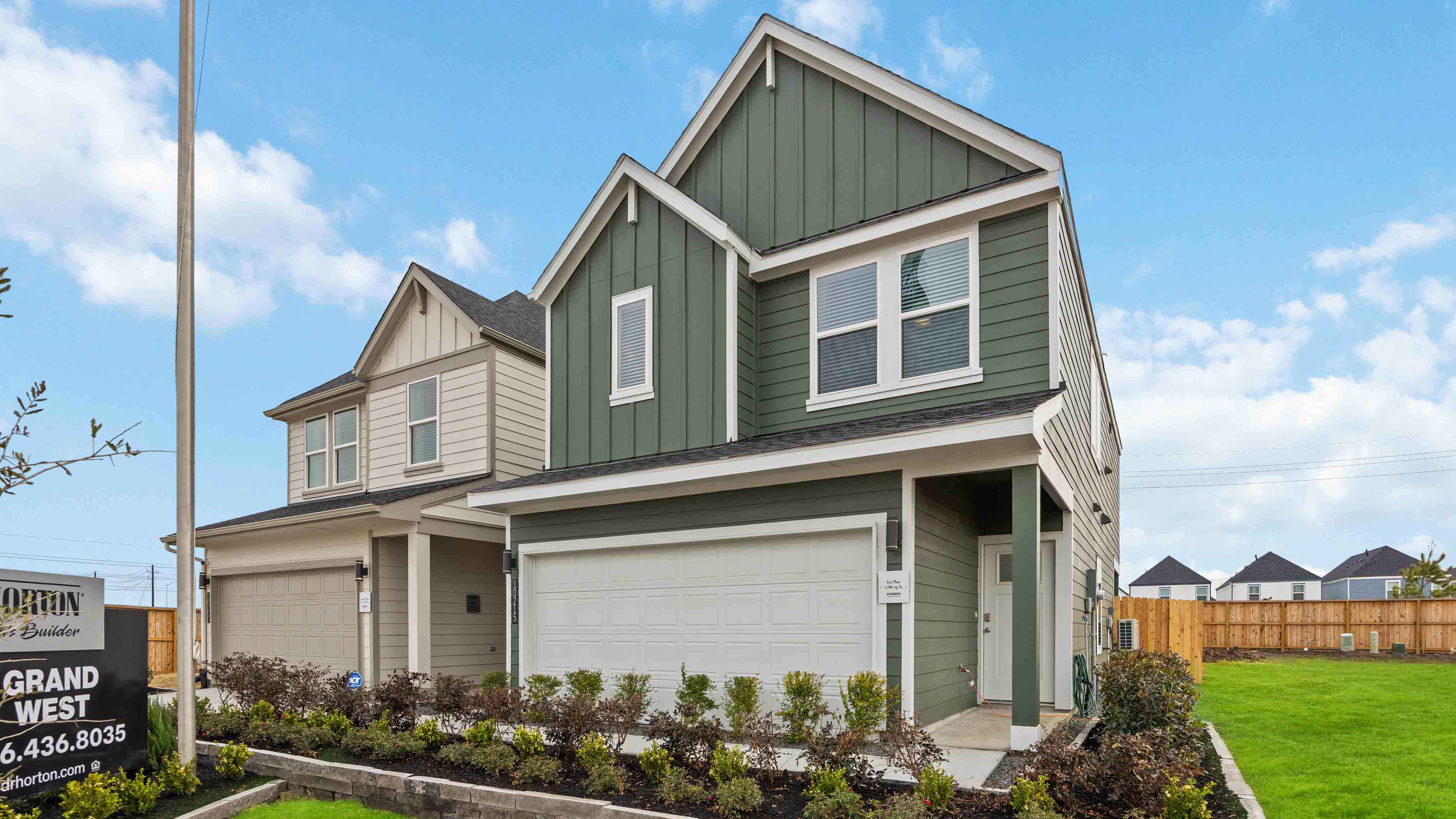 Modern two-story home with a siding exterior, two-car garage, and well-maintained front lawn in a urban neighborhood