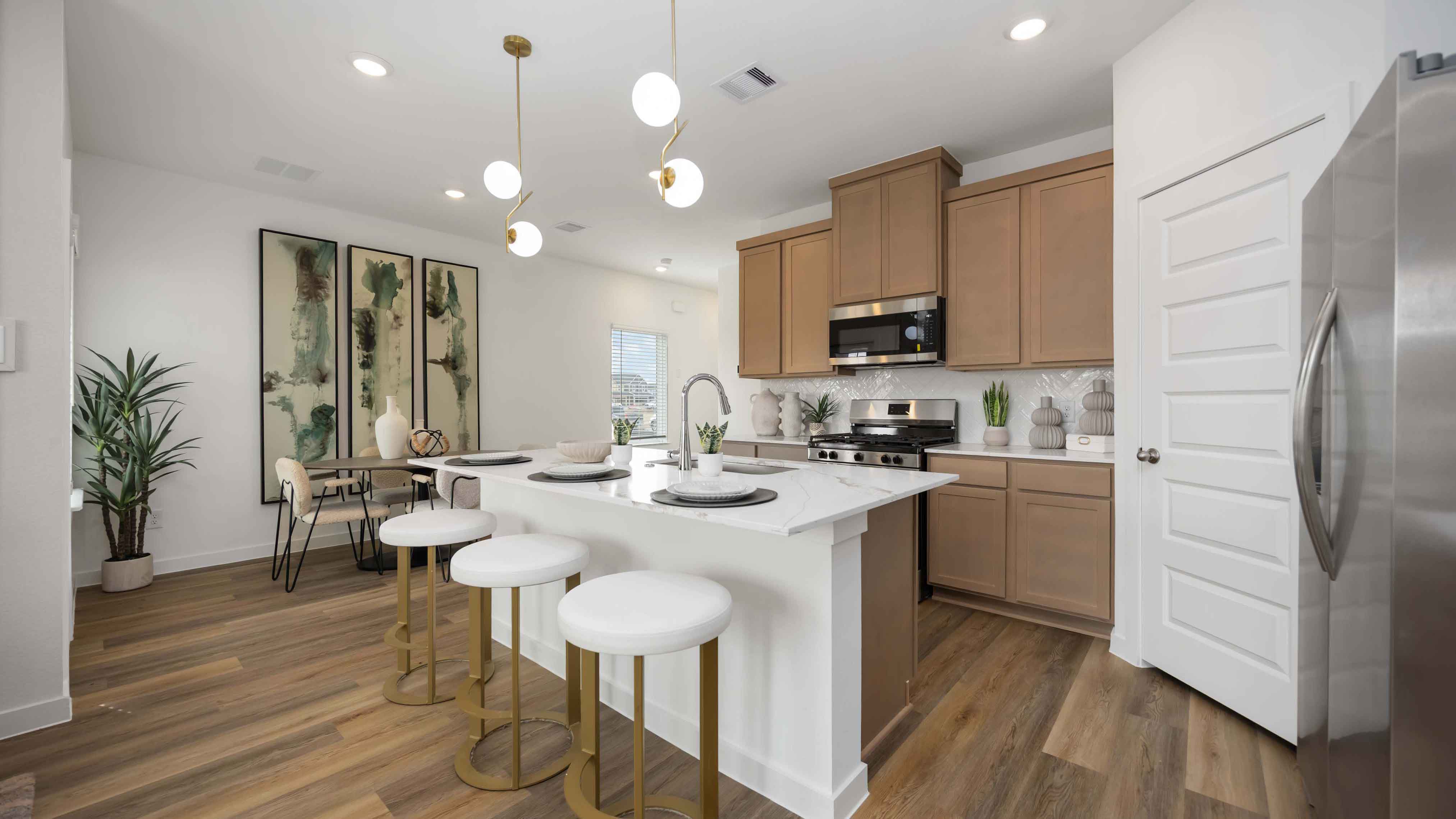 beautiful new kitchen with quartz counters, light grey cabinets, and herringbone backsplash