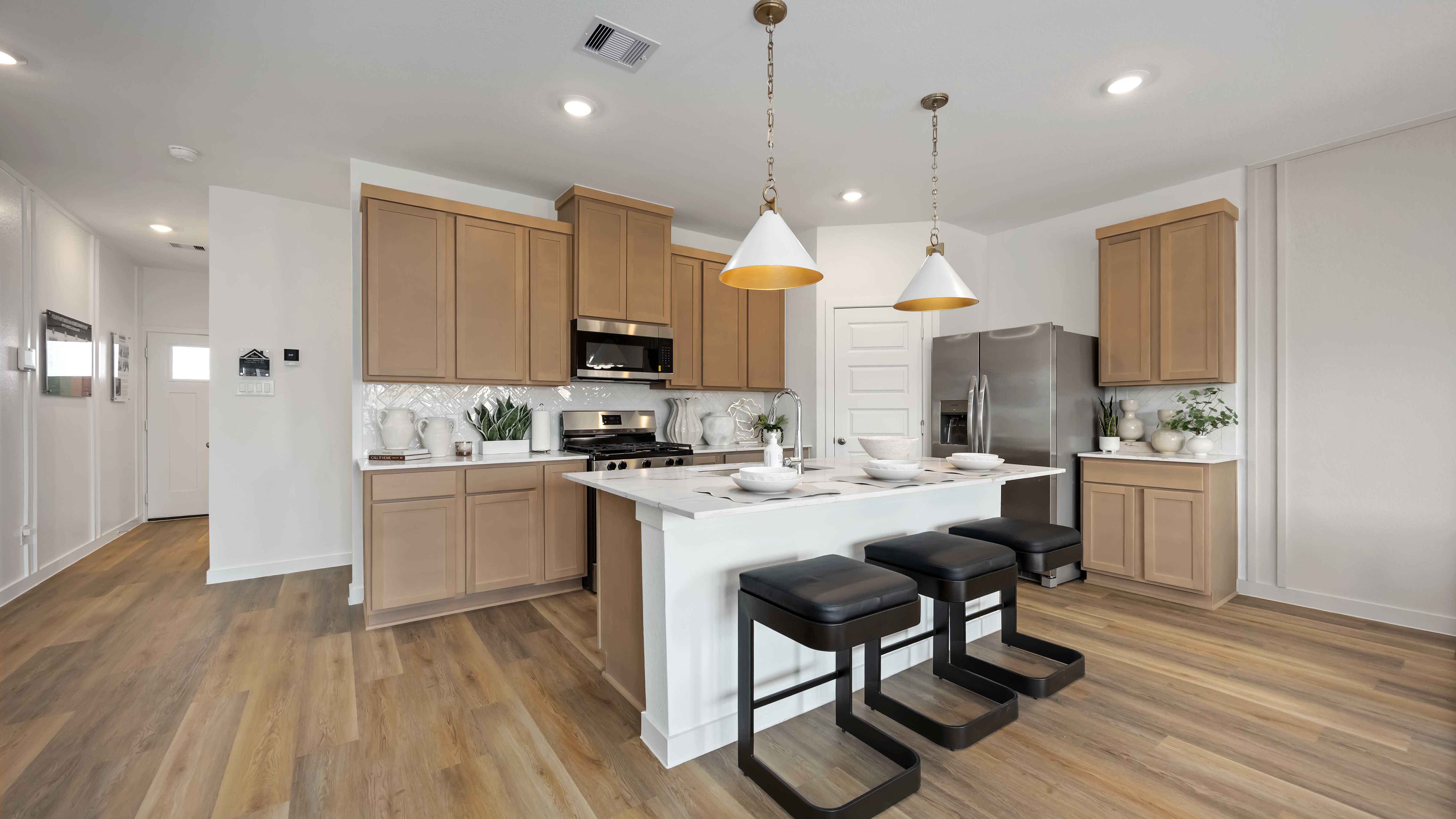 beautiful new kitchen with quartz counter tops, wood cabinets, and herringbone backsplash
