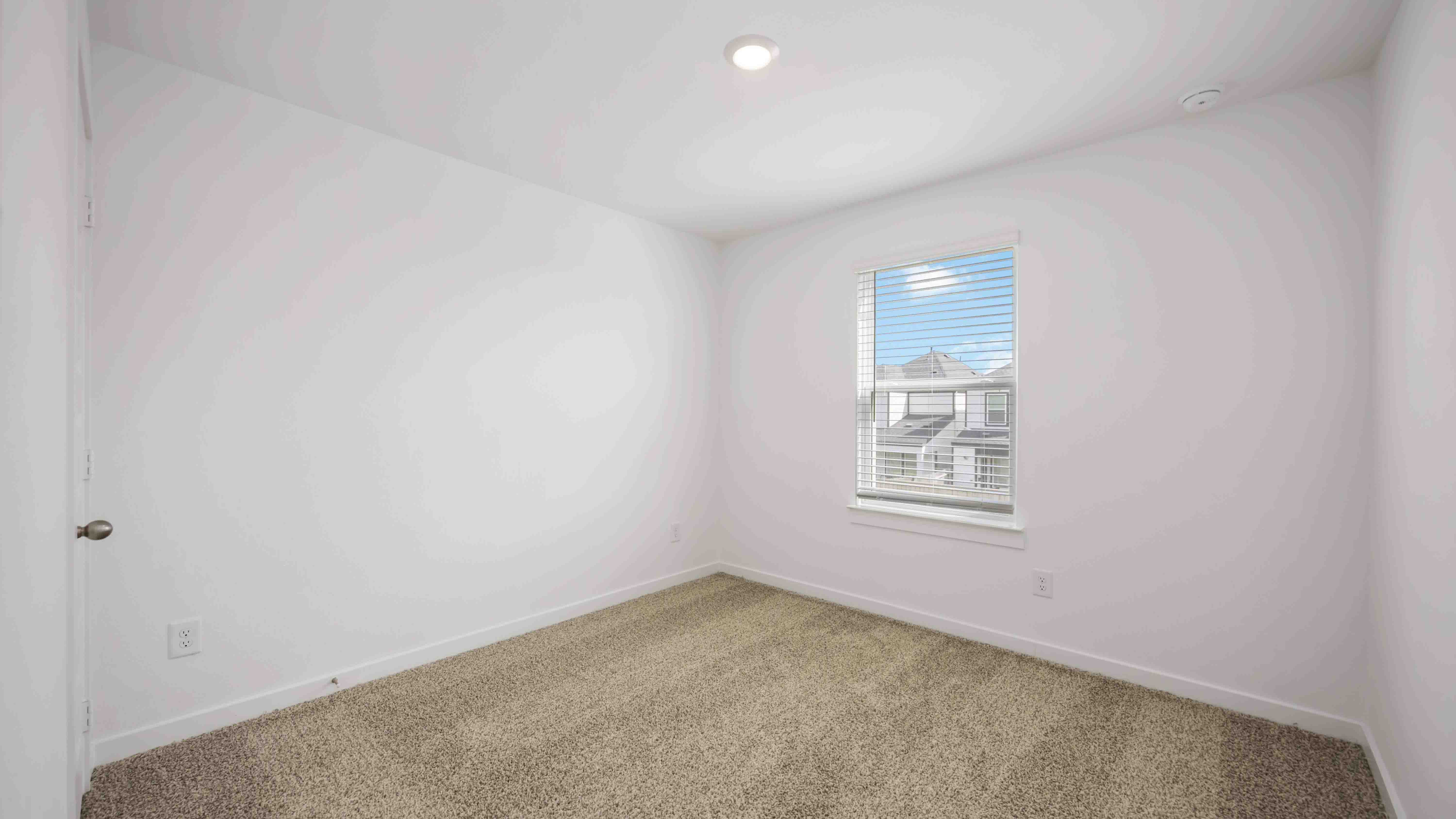 third bedroom has light neutral walls and carpet flooring
