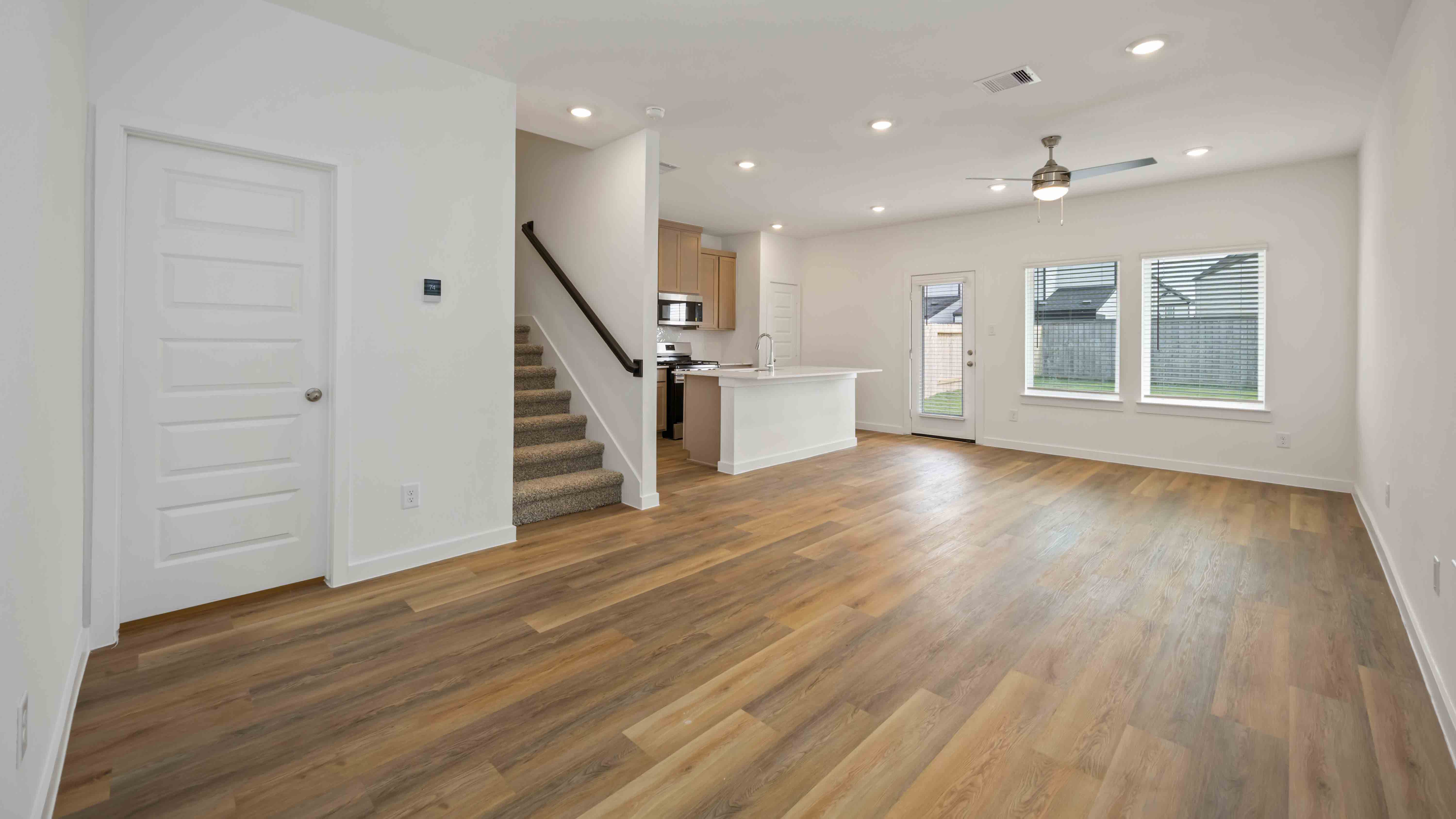 spacious living room with plenty of natural light from windows overlooking the backyard